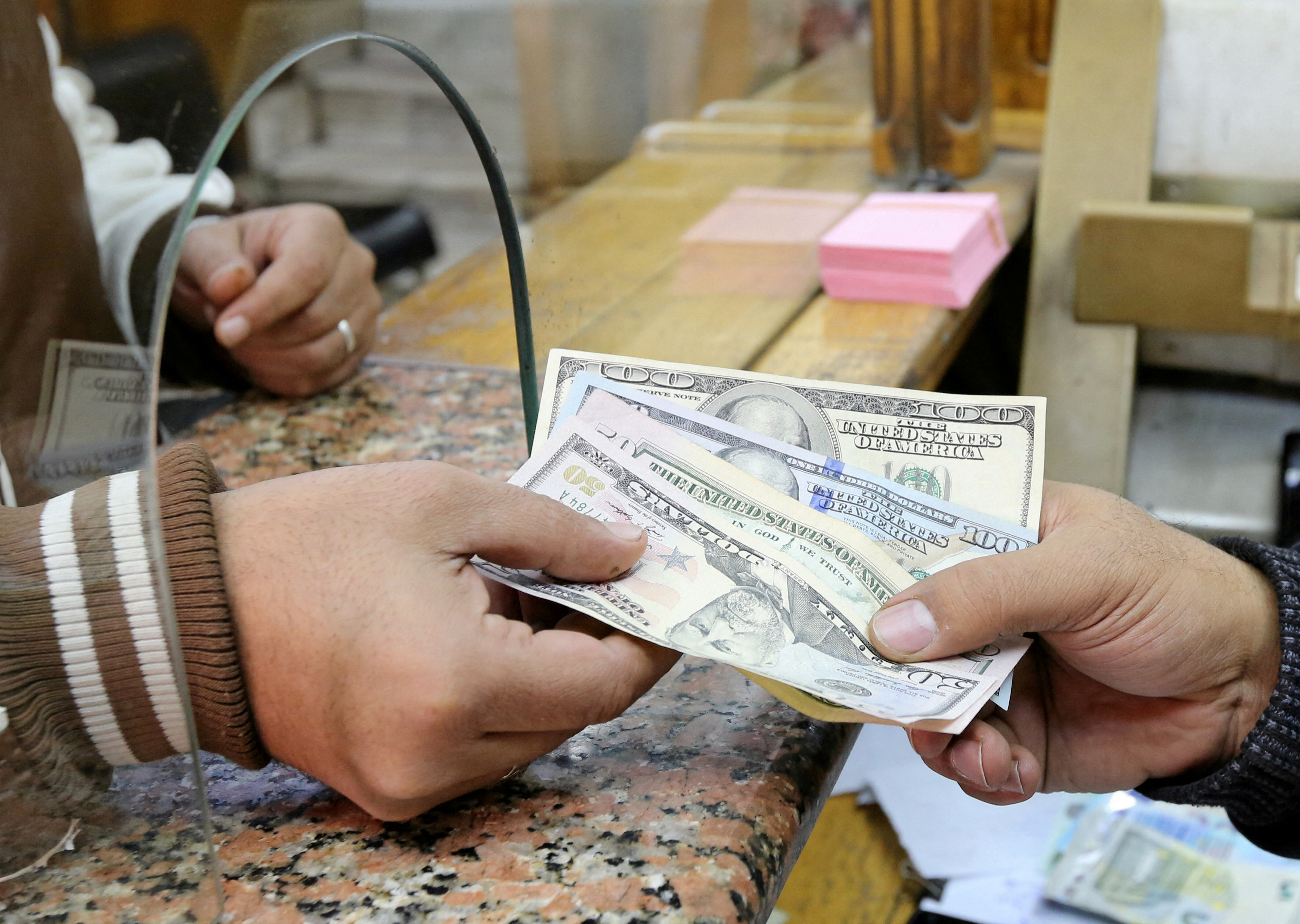 A customer exchanges U.S. dollars to Egyptian pounds in a foreign exchange office in central Cairo