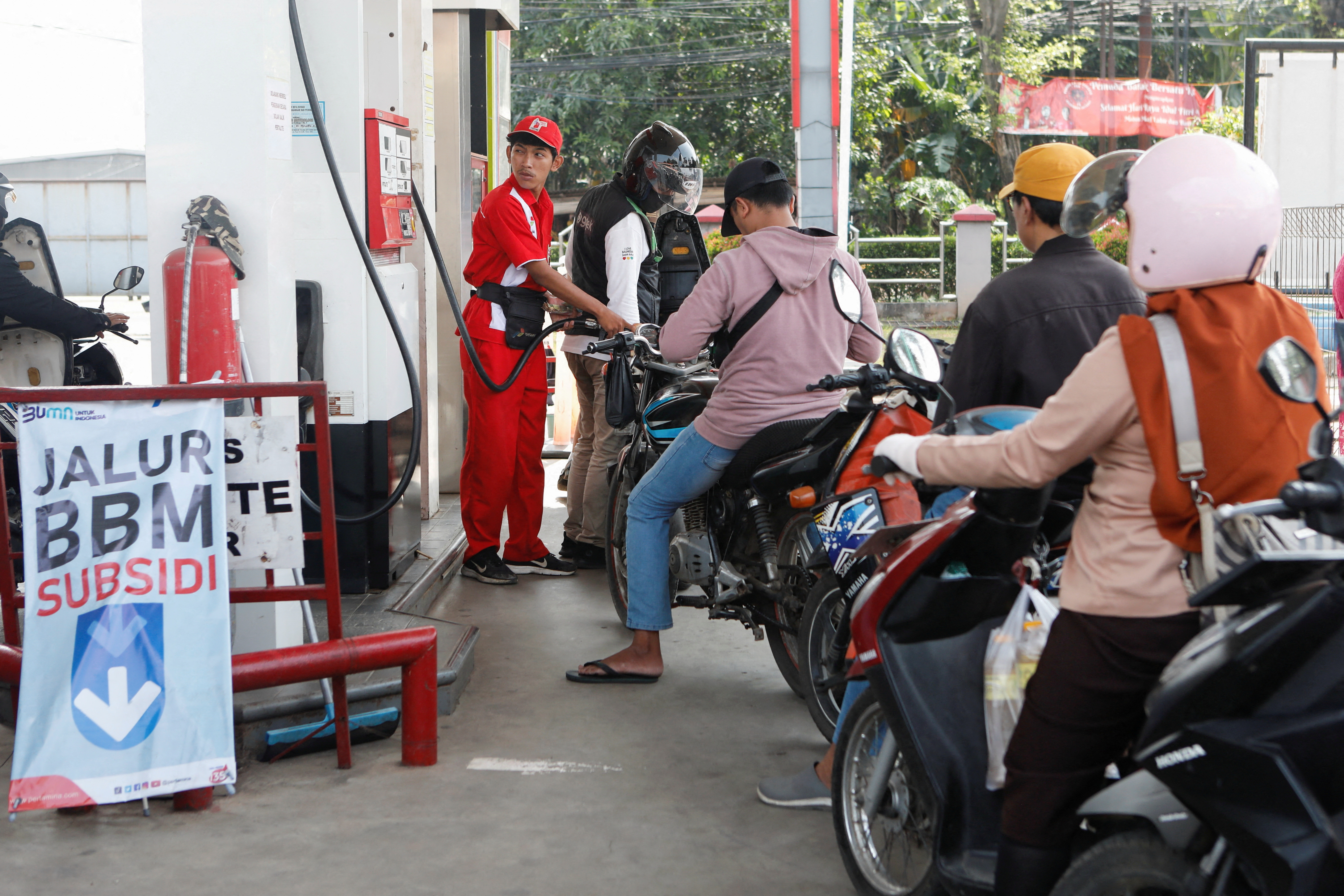 A worker of a petrol station of the state-owned company Pertamina fills a motorcycle with subsidised fuel after the announcement of a fuel price hike, in Bekasi
