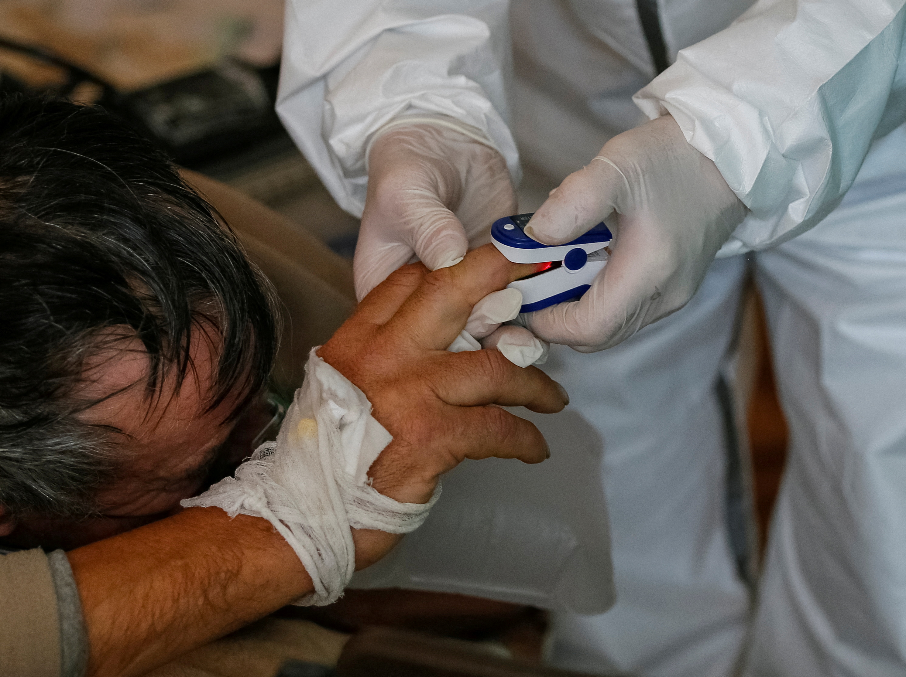 A medical specialist takes care of a patient suffering from the coronavirus disease (COVID-19) at a hospital in the town of Ovruch, Zhytomyr region, Ukraine November 10, 2021. REUTERS/Gleb Garanich