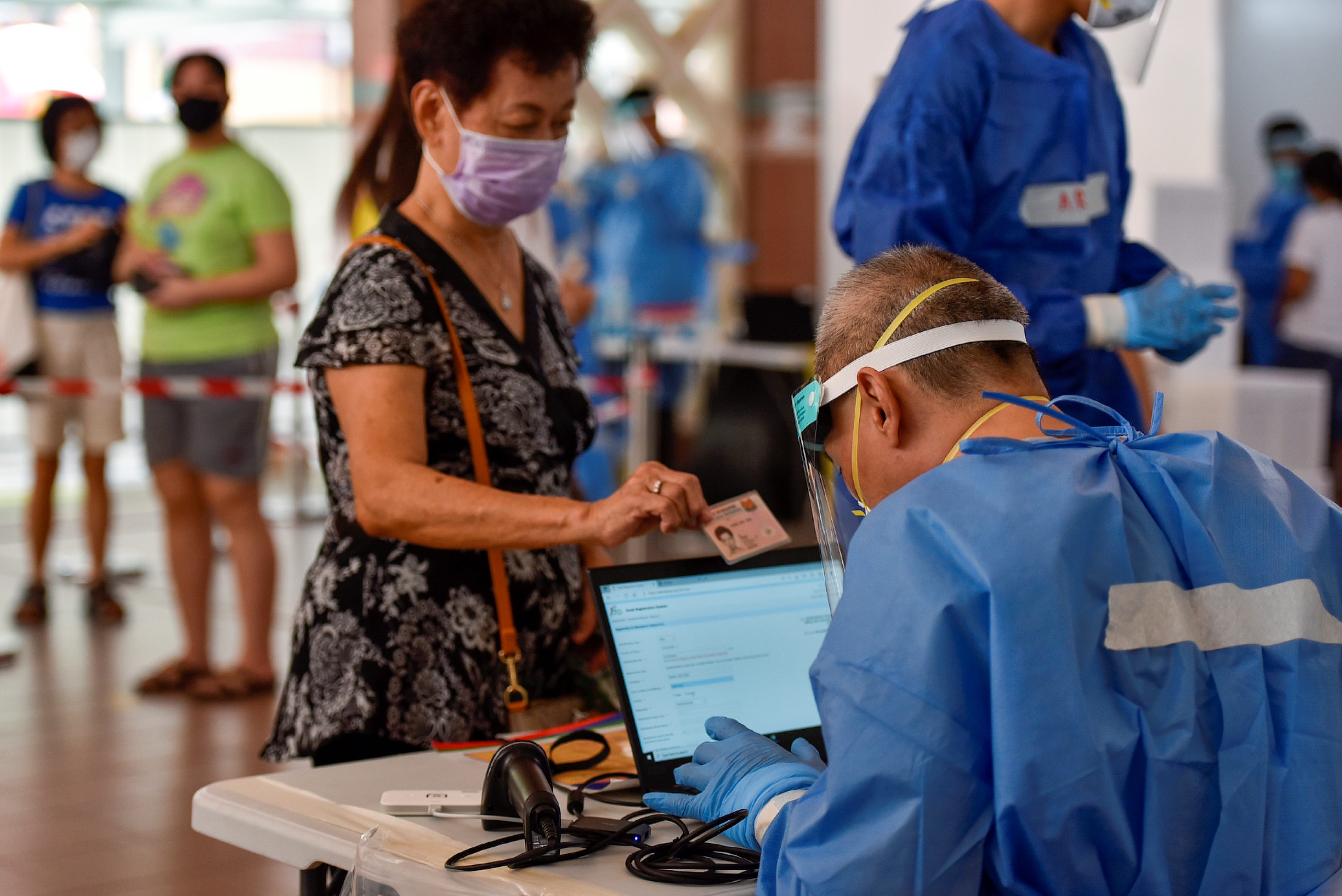 Swab tests are conducted at a public housing estate after a nearby food centre became a COVID-19 cluster in Singapore