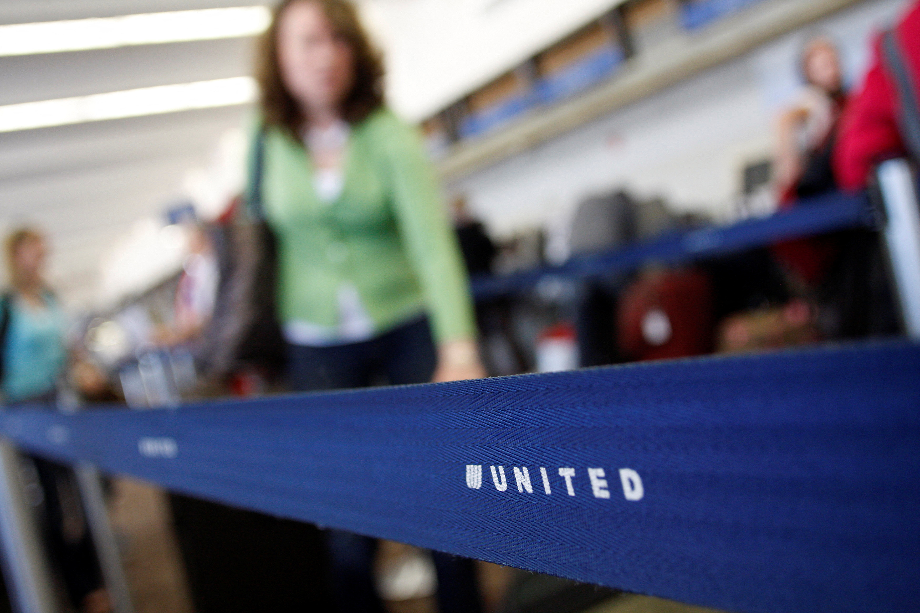 Passengers wait to check-in at the United Airlines ticket counter at Phoenix Sky Harbor International Airport