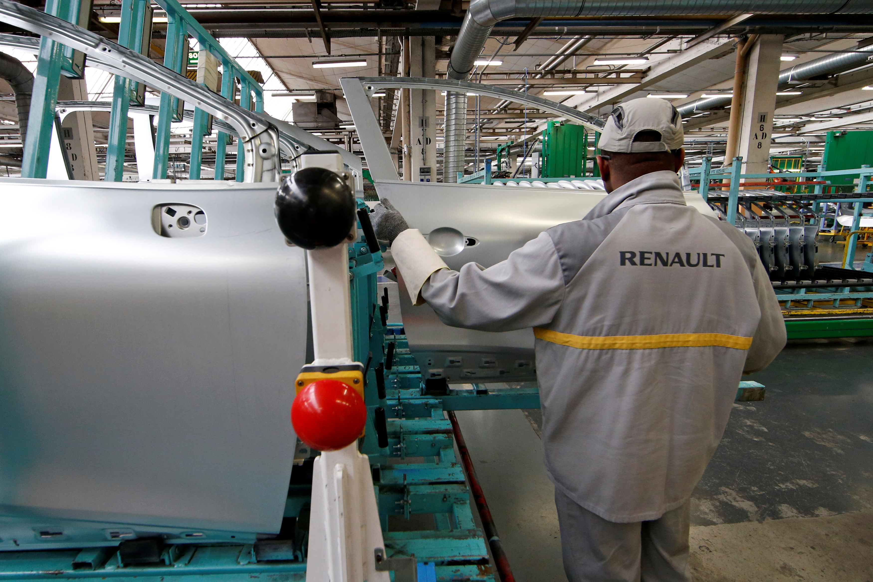 An employee works on the automobile assembly line of a Renault Clio IV at the Renault automobile factory in Flins