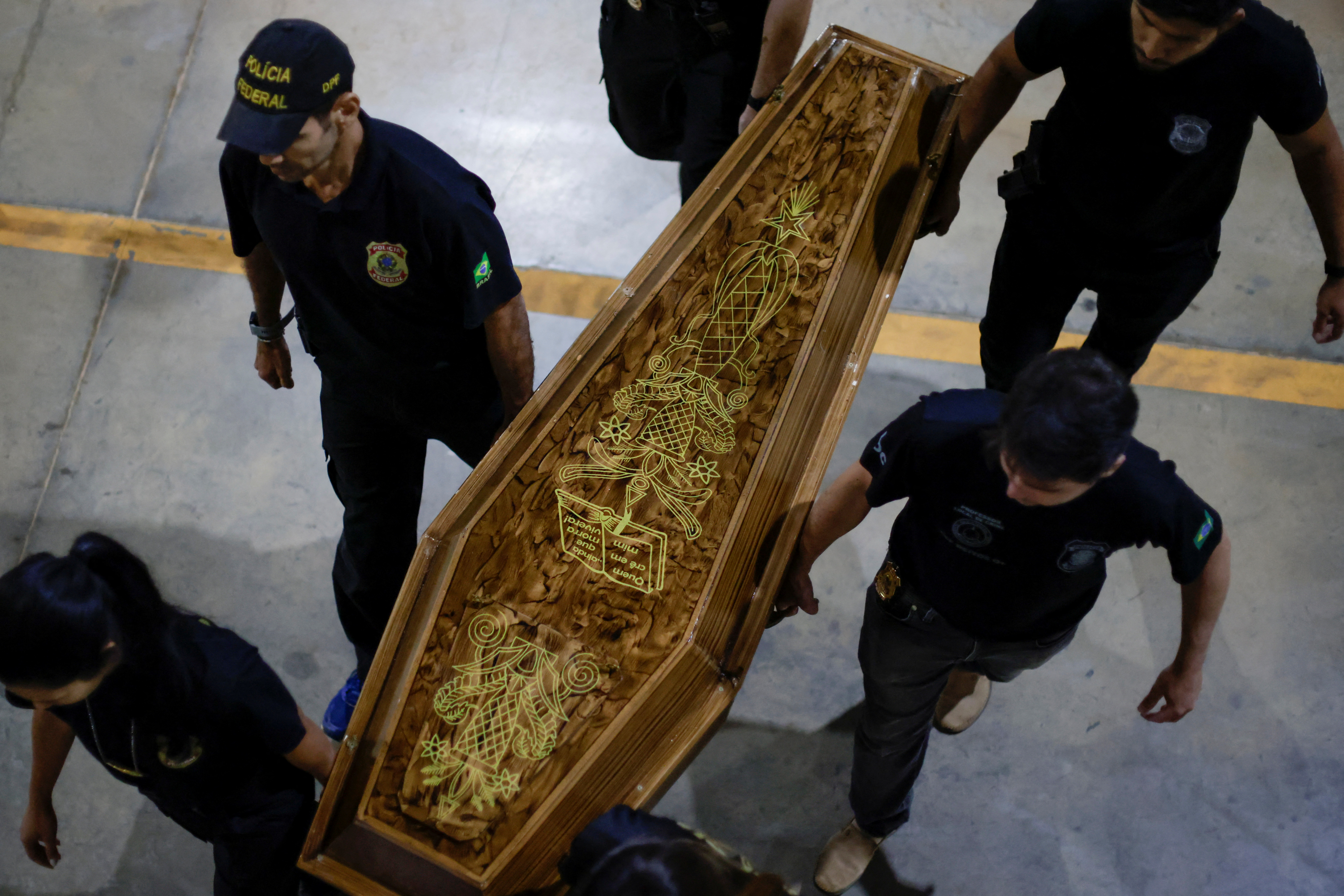 افسران پلیس فدرال پس از اعتراف مظنون به قتل روزنامه‌نگار بریتانیایی دام فیلیپس و کارشناس بومی برزیلی برونو پریرا در برازیلیا، تابوتی حاوی بقایای انسانی حمل می‌کنند.