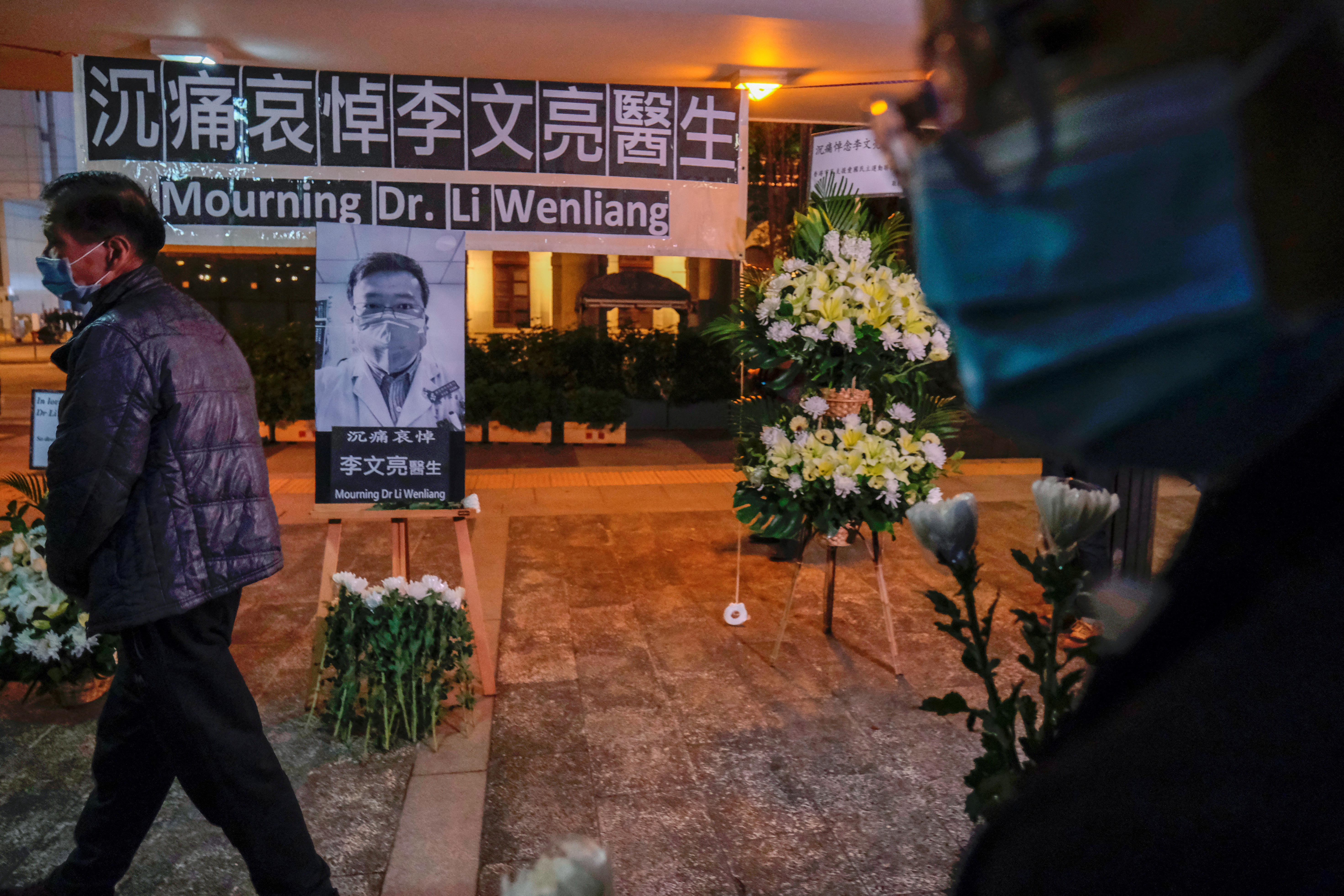 People wearing masks attend a vigil for late Li Wenliang, an ophthalmologist who died of coronavirus at a hospital in Wuhan, in Hong Kong
