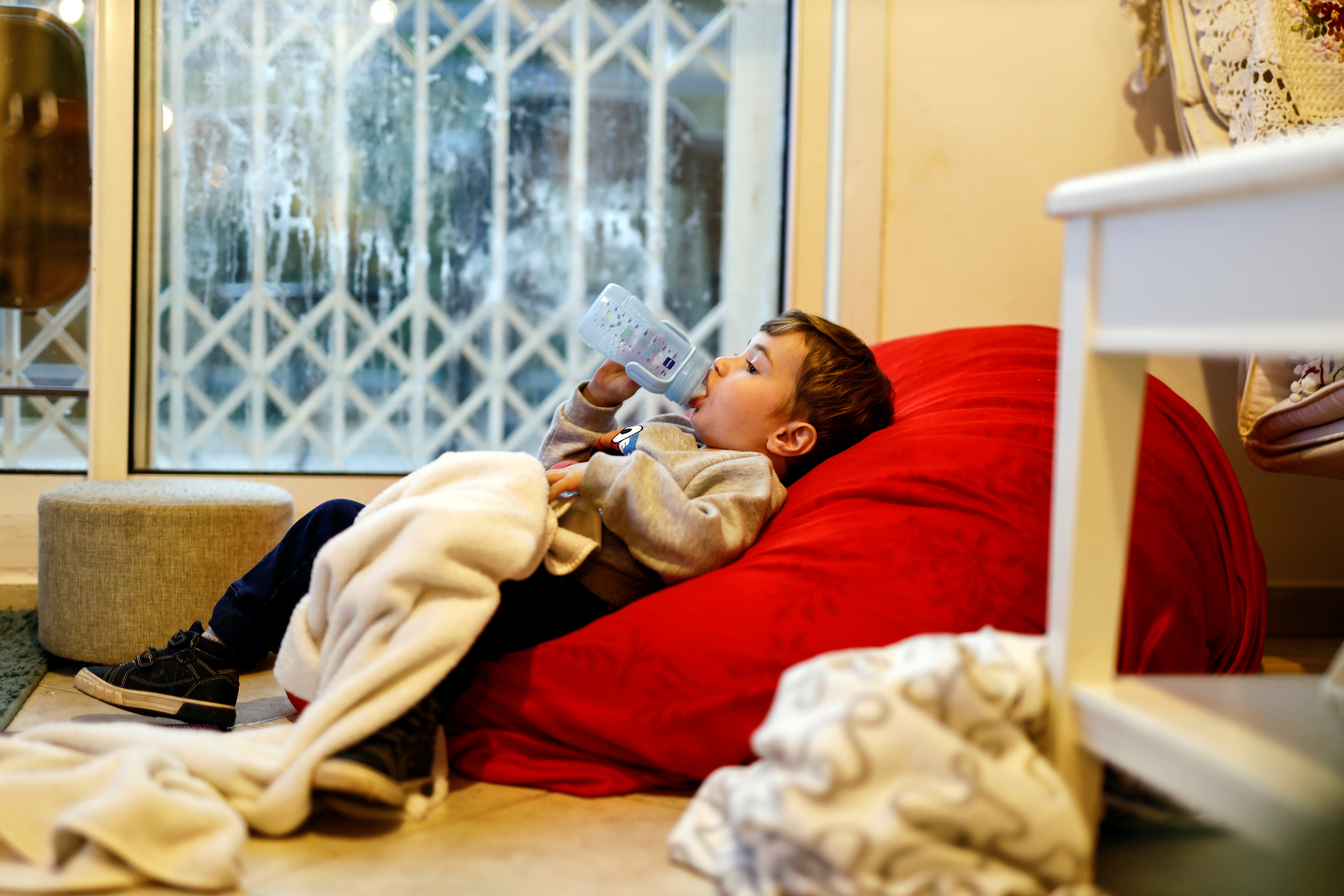 Eran, a 3-year-old Israeli boy who suffered from PIMS, a rare consequence of COVID-19, drinks from a bottle, in Tzur Hadassah