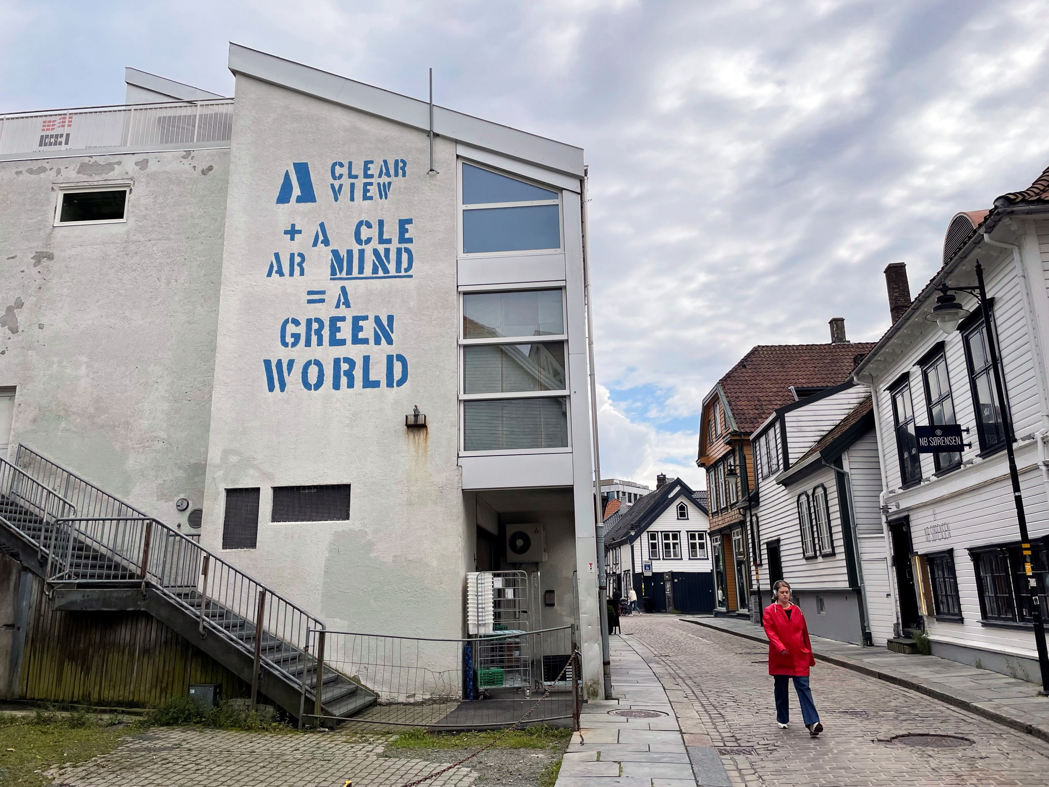 Woman walks past a building in the city of Stavanger