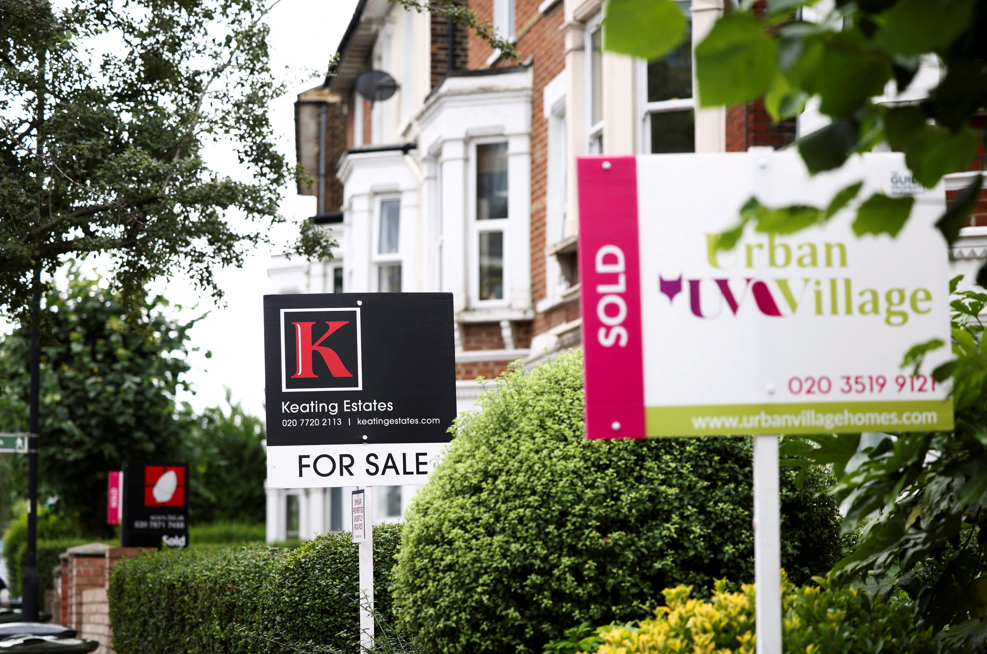 Estate agent signs are seen outside a residential housing in south London