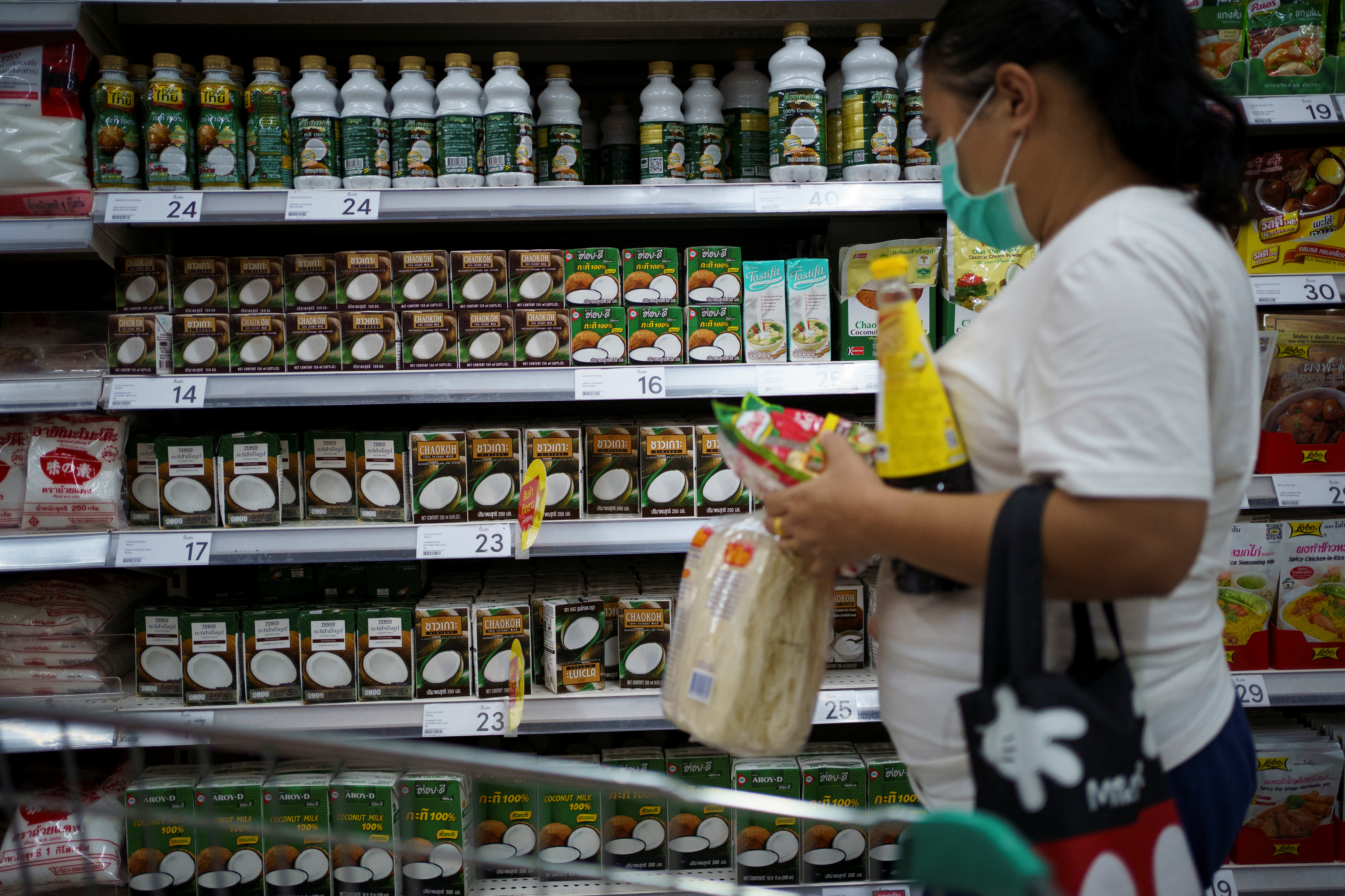 A woman shops coconut products at a supermarket in Bangkok