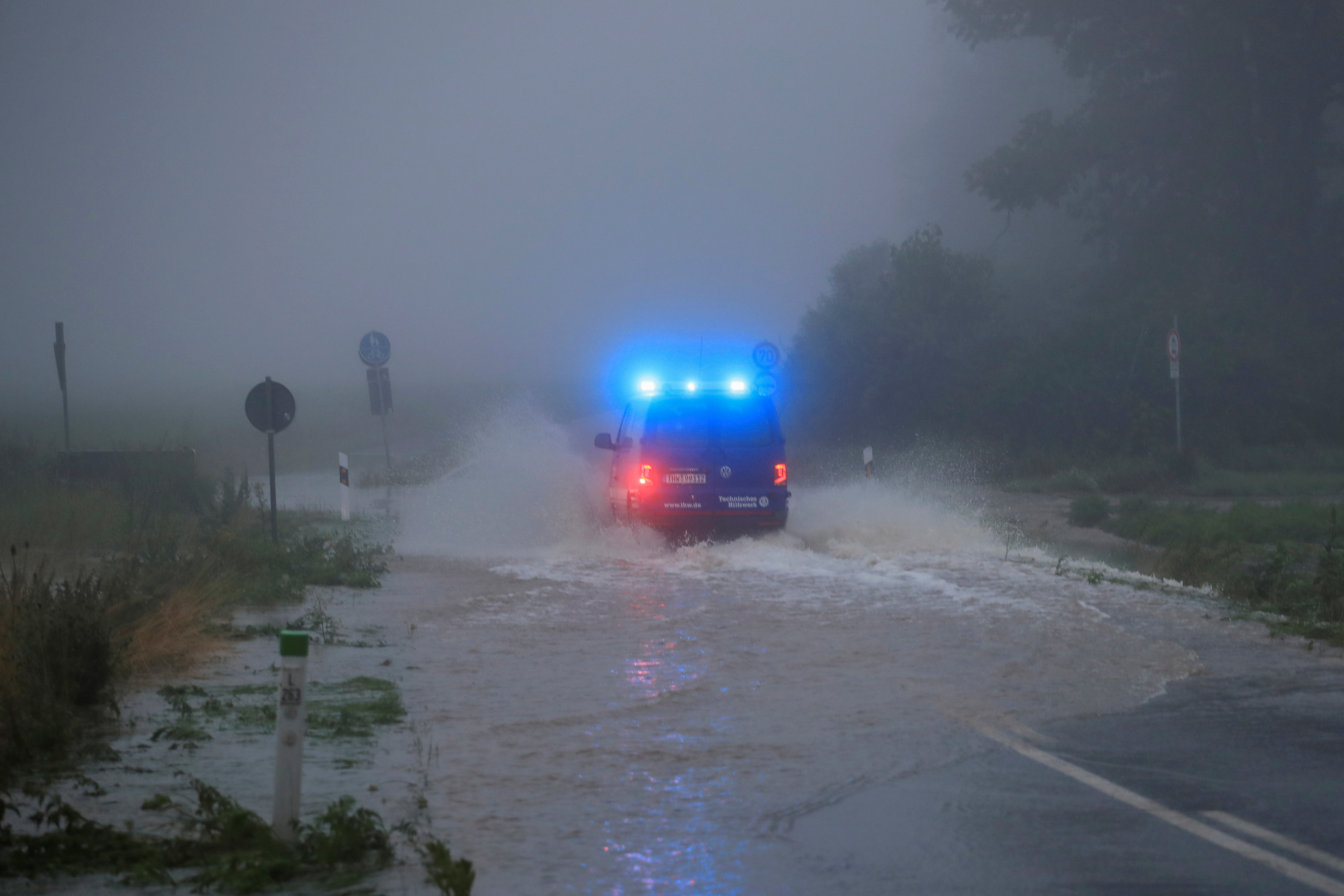 A vehicle travels on a flood affected road after the Erft river swelled following heavy rainfalls in Erftstadt, near Cologne, Germany, July 15, 2021. REUTERS/Wolfgang Rattay
