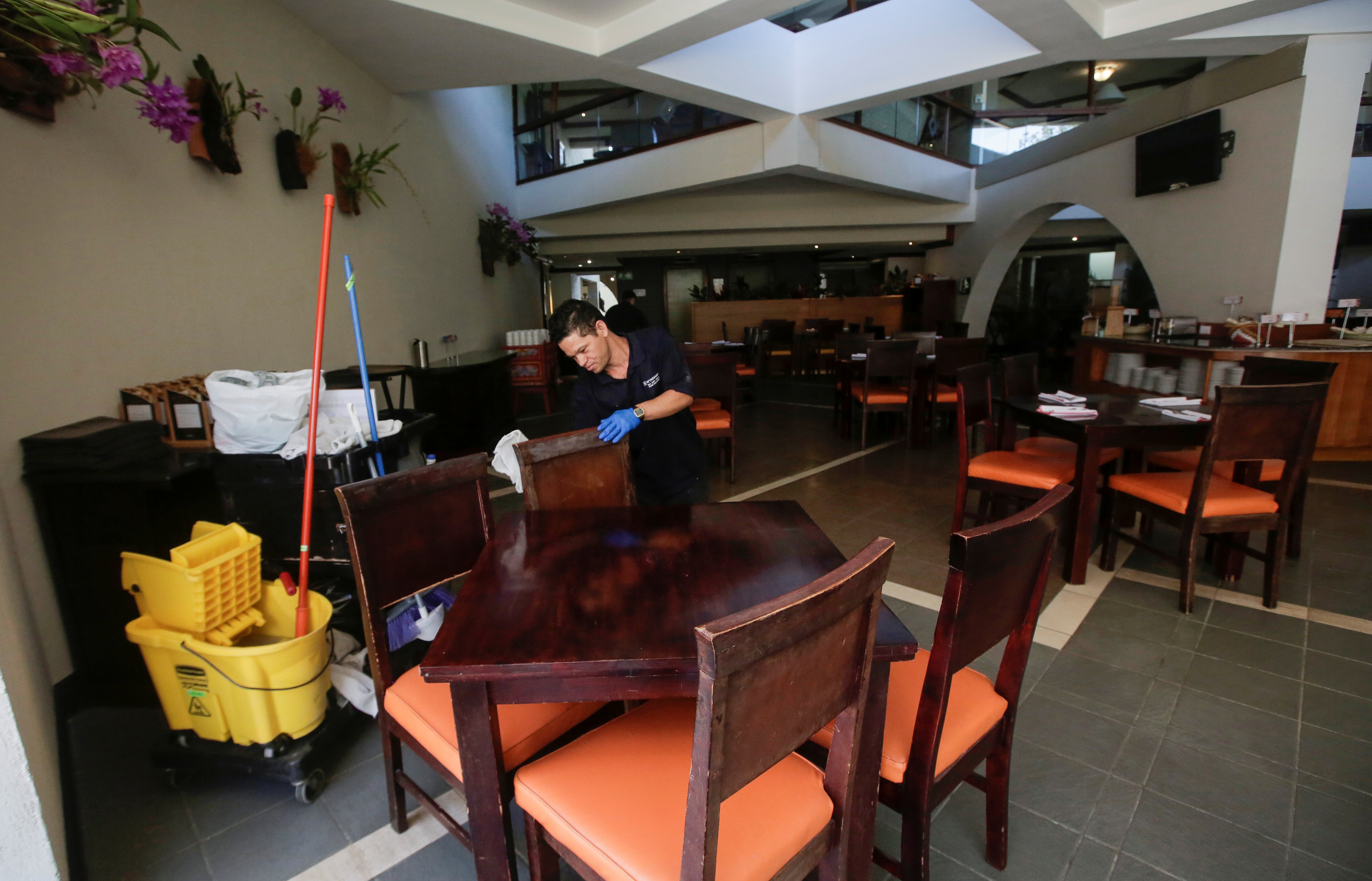 An employee cleans a restaurant chair in a hotel, as Costa Rica tourism industry braces for coronavirus disease (COVID-19) outbreak, in Heredia, Costa Rica March 18, 2020. Picture taken March 18,2020. REUTERS/Juan Carlos Ulate