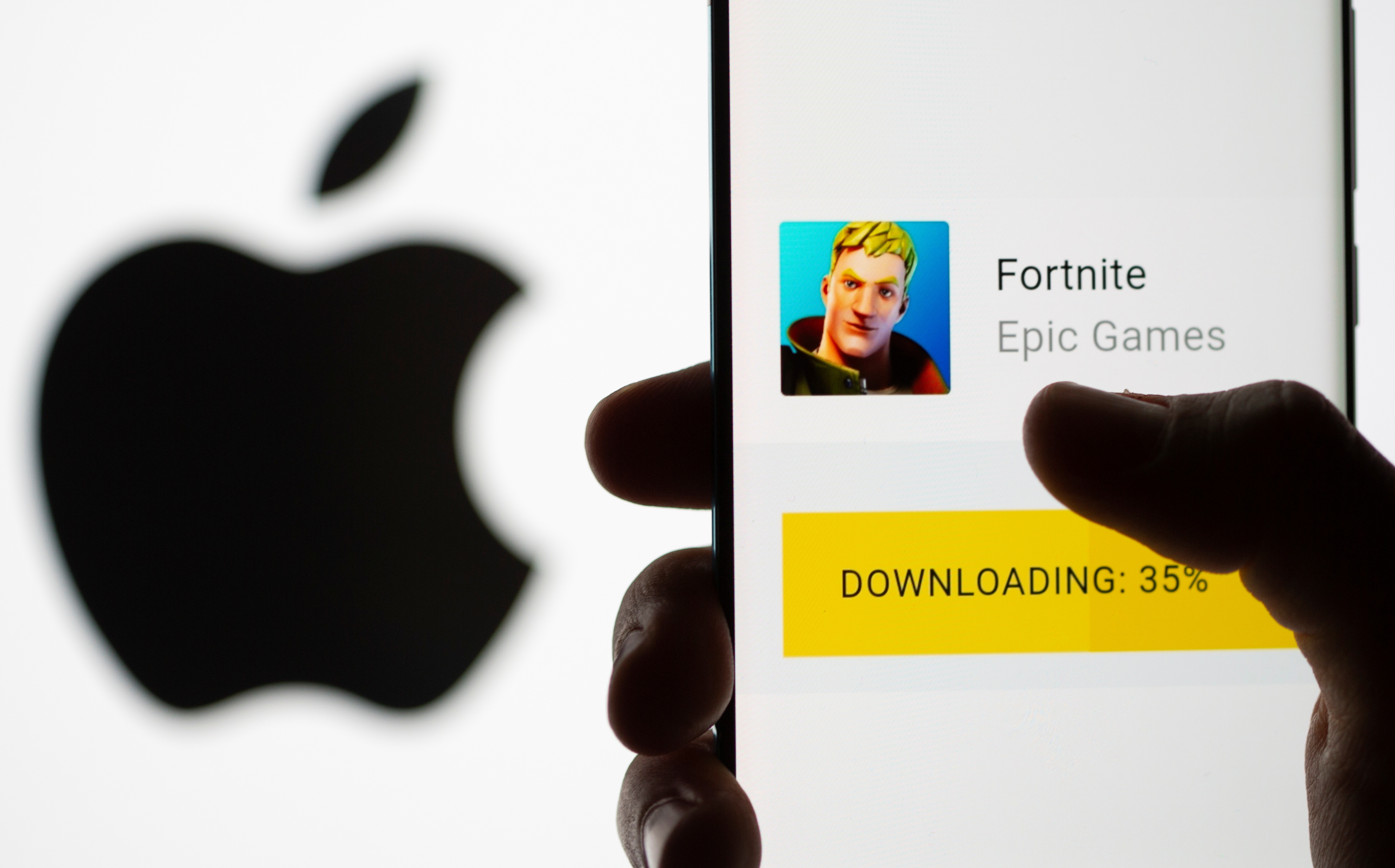 Fortnite download on Android operating system is seen in front of Apple logo in this illustration