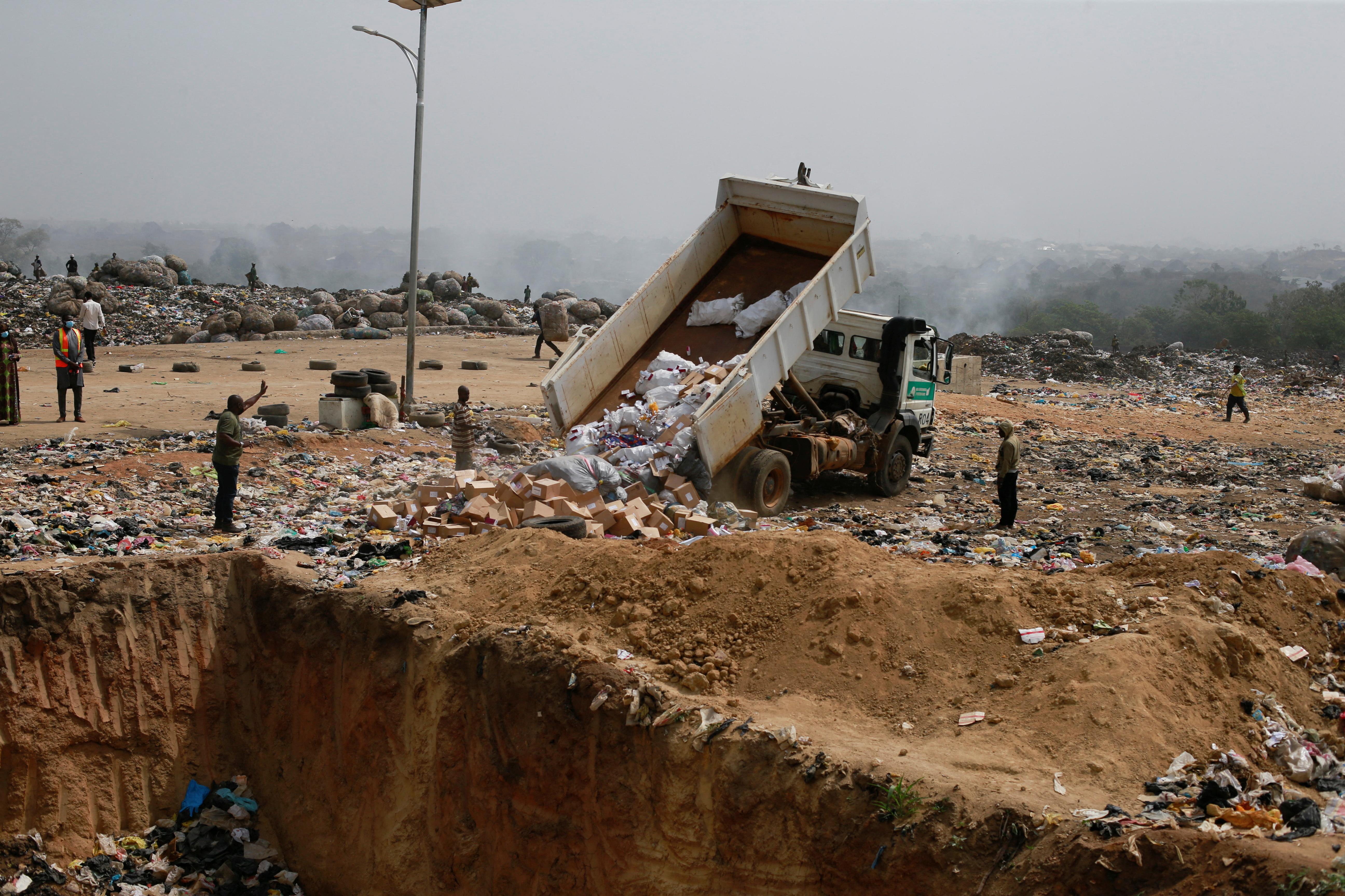 A truck trips off expired AstraZeneca COVID-19 vaccines at the Gosa dump site in Abuja