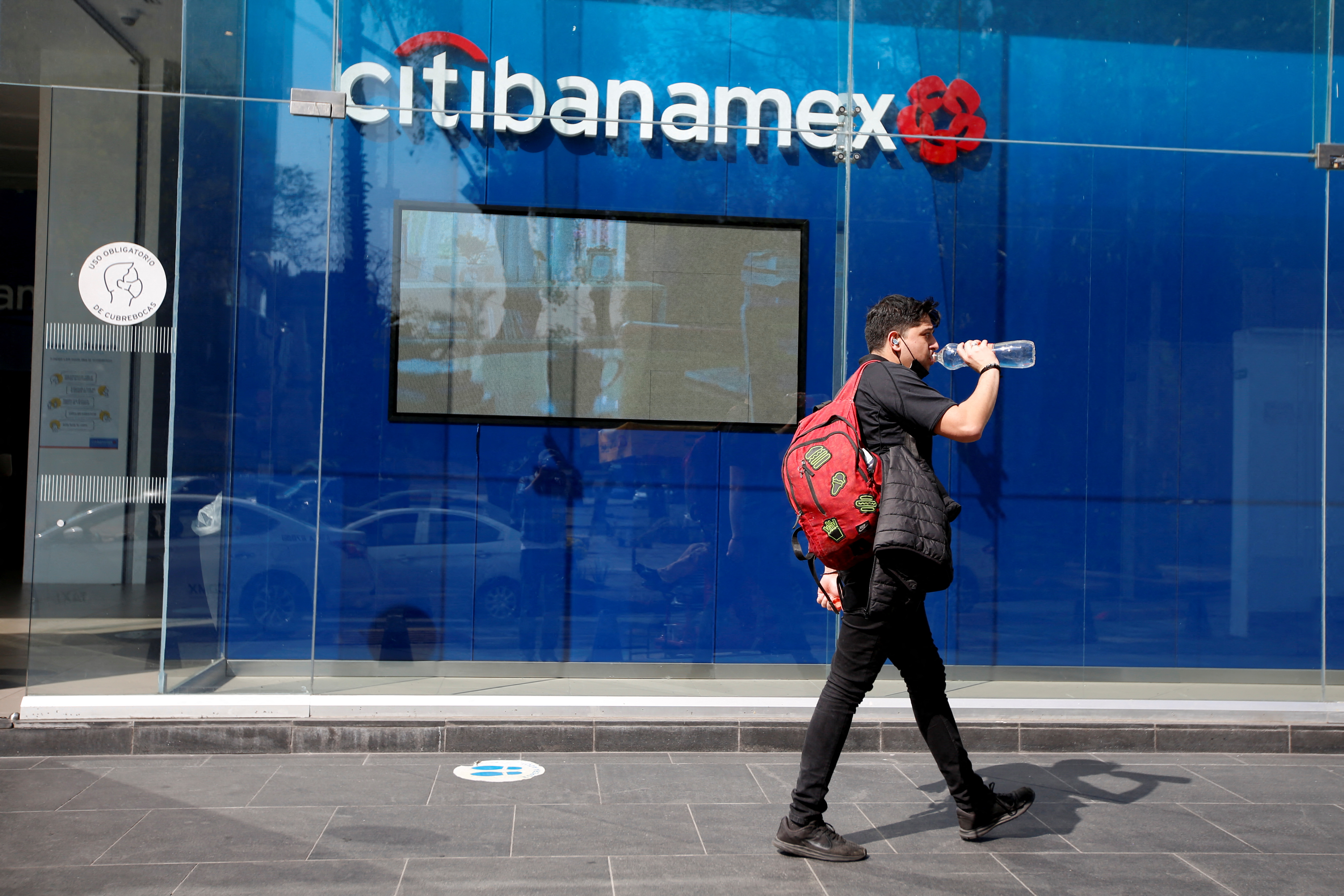 A man walks past a Citibanamex bank branch in Mexico City