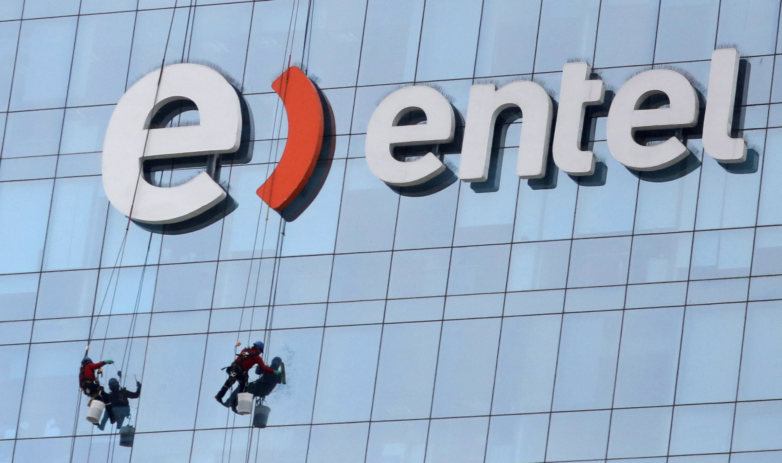 Workers clean the windows of the office building of Chilean telecommunications company Entel at the district of San Isidro in Lima