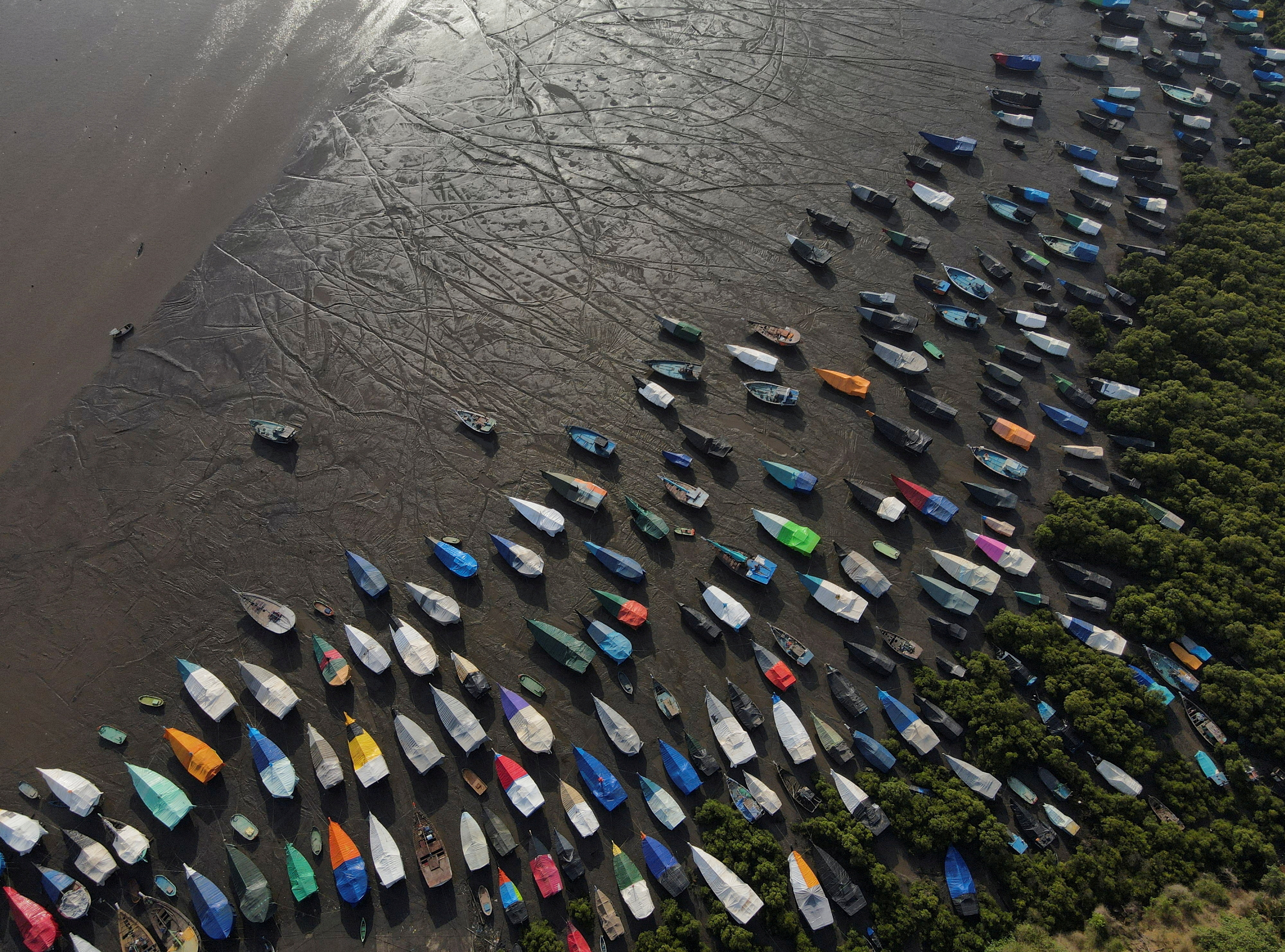 An aerial view of fishing boats covered with tarpaulin sheets parked on the shore, before the start of the monsoon season, on the outskirts of Mumbai
