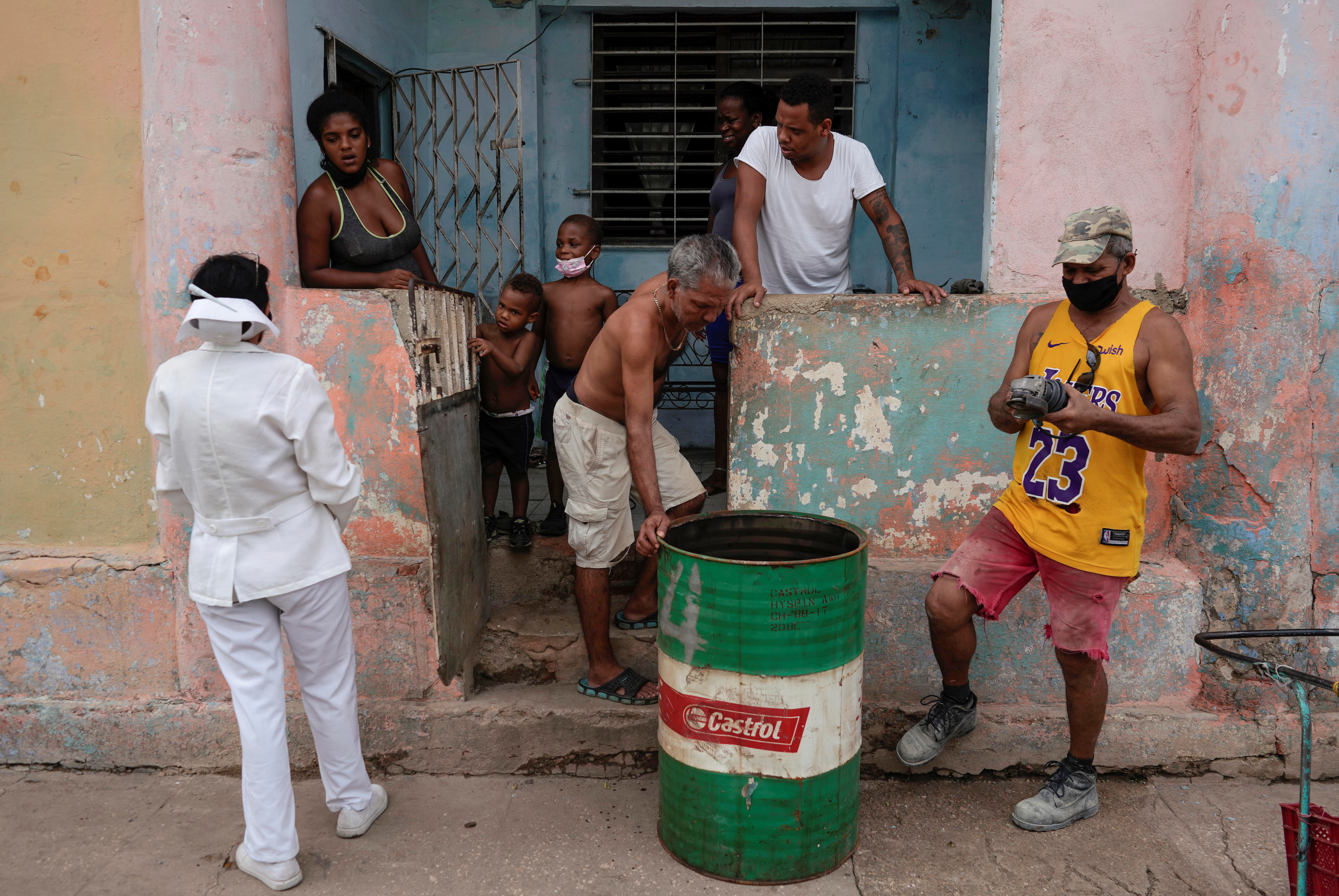 A nurse asks a family to go to a vaccination center in Havana