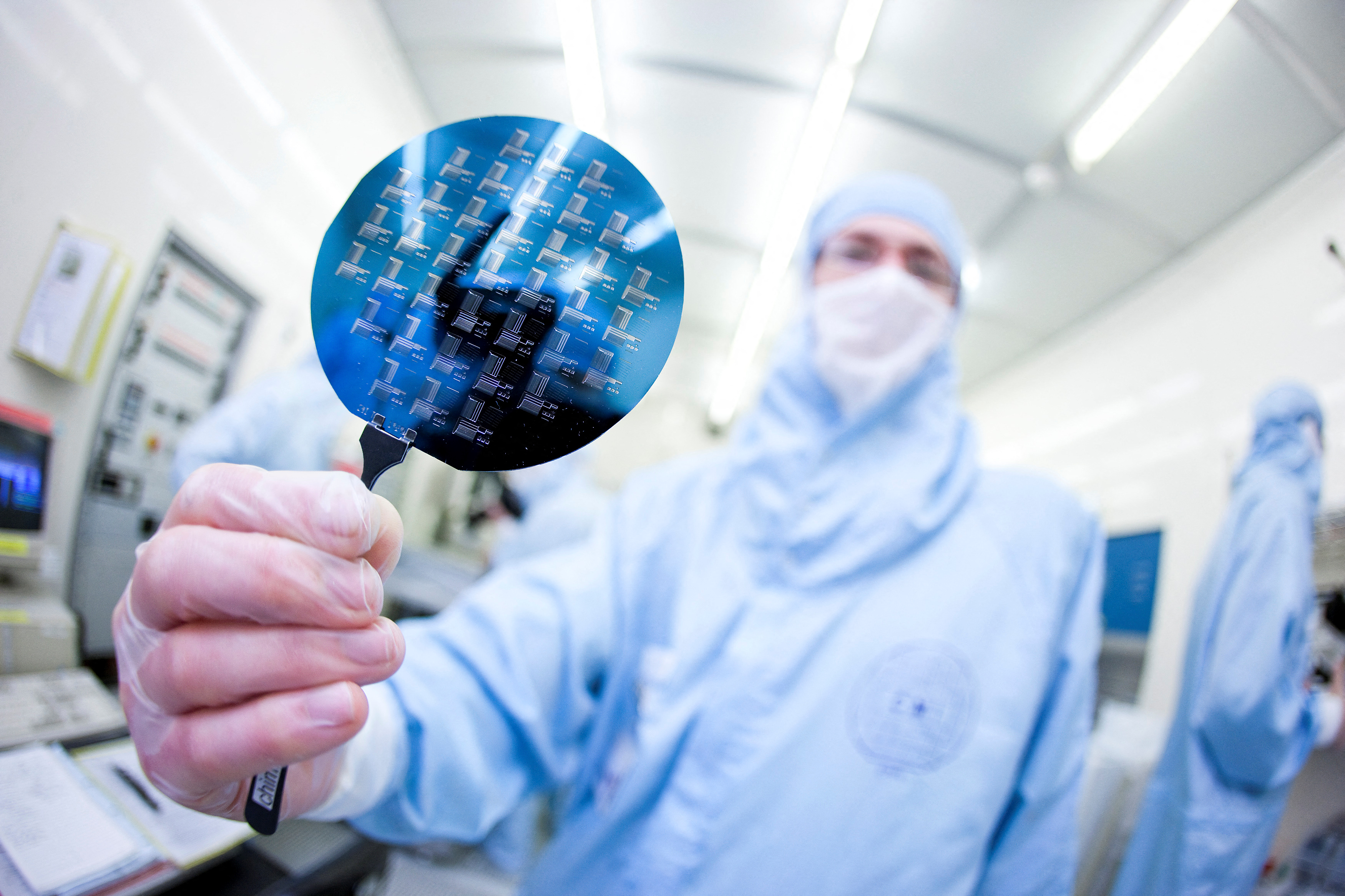A scientist presents a silicon wafer during a media presentation in one of the low particle pollution nanofabrication clean rooms of the Swiss Federal Institute of Technology
