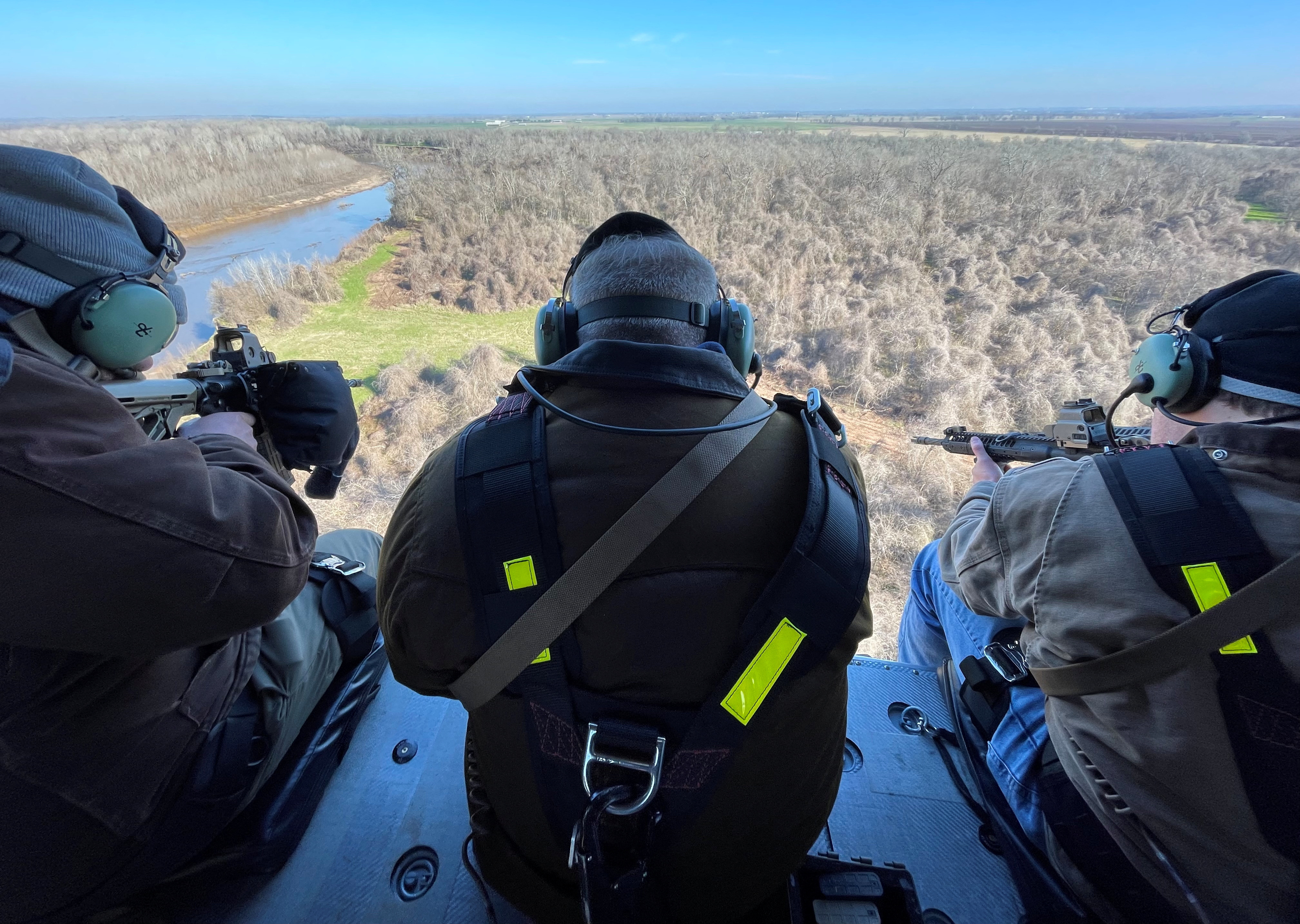Three hunters aboard a HeliBacon helicopter hunt for feral hogs in Bryan