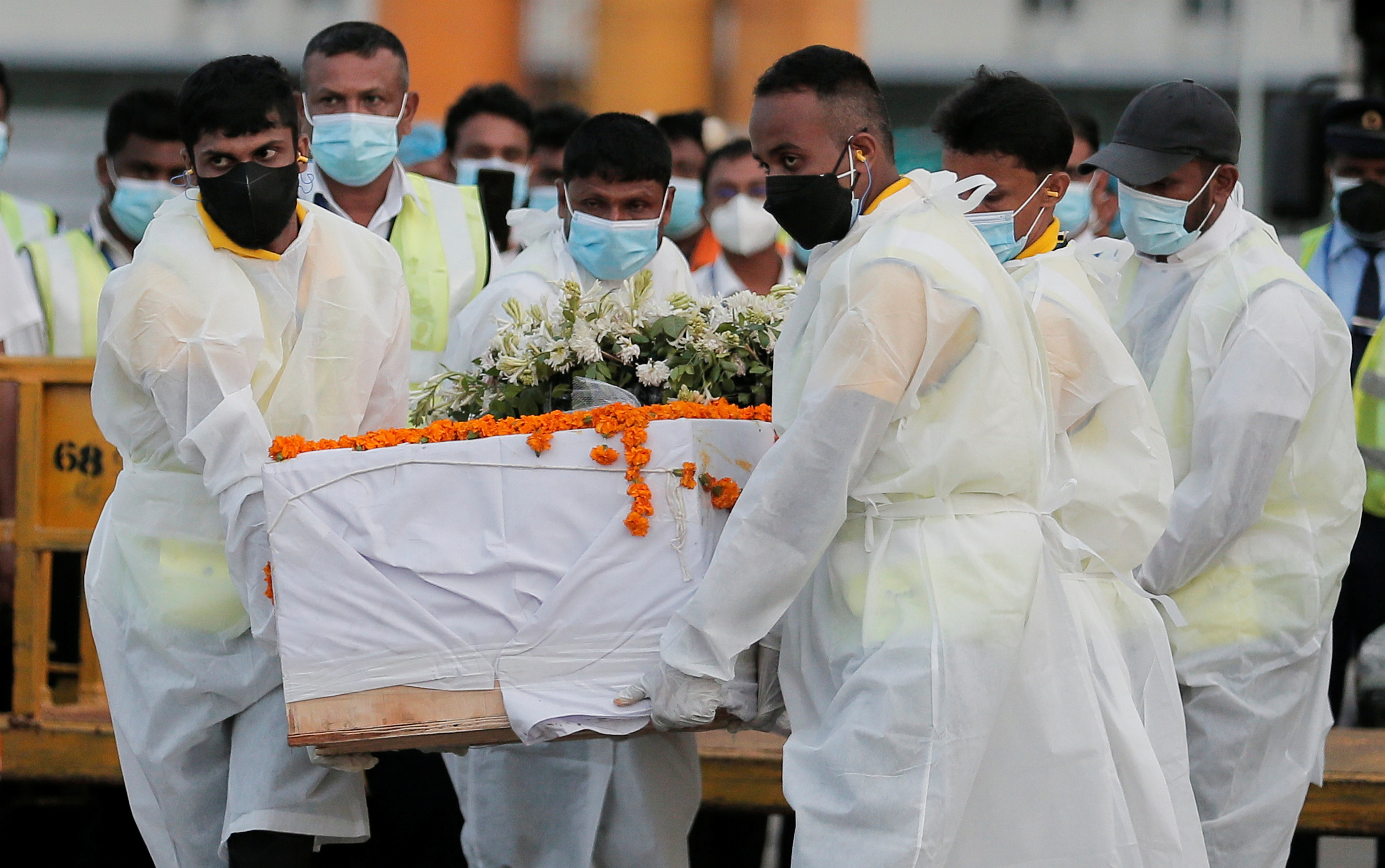 Airport staff carry the coffin with remains of Sri Lankan national Priyantha Kumara, who was beaten to death and burnt by the mob in Punjab province on last Friday, at Bandaranaike International Airport, in Katunayake, Sri Lanka December 6, 2021. REUTERS/Dinuka Liyanawatte
