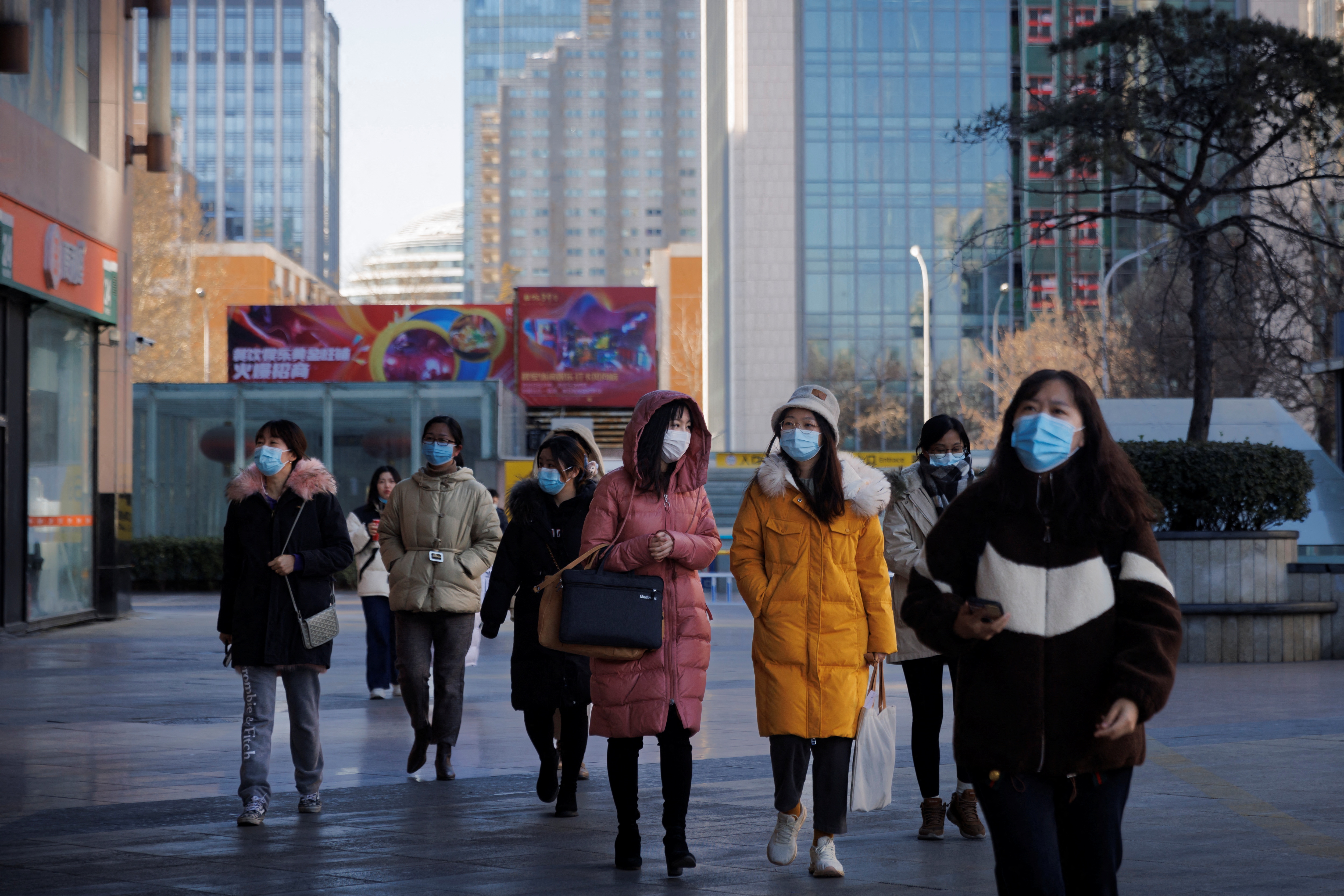 People walk on a street as the coronavirus disease (COVID-19) outbreak continues in Beijing, China, January 13, 2022. REUTERS/Thomas Peter