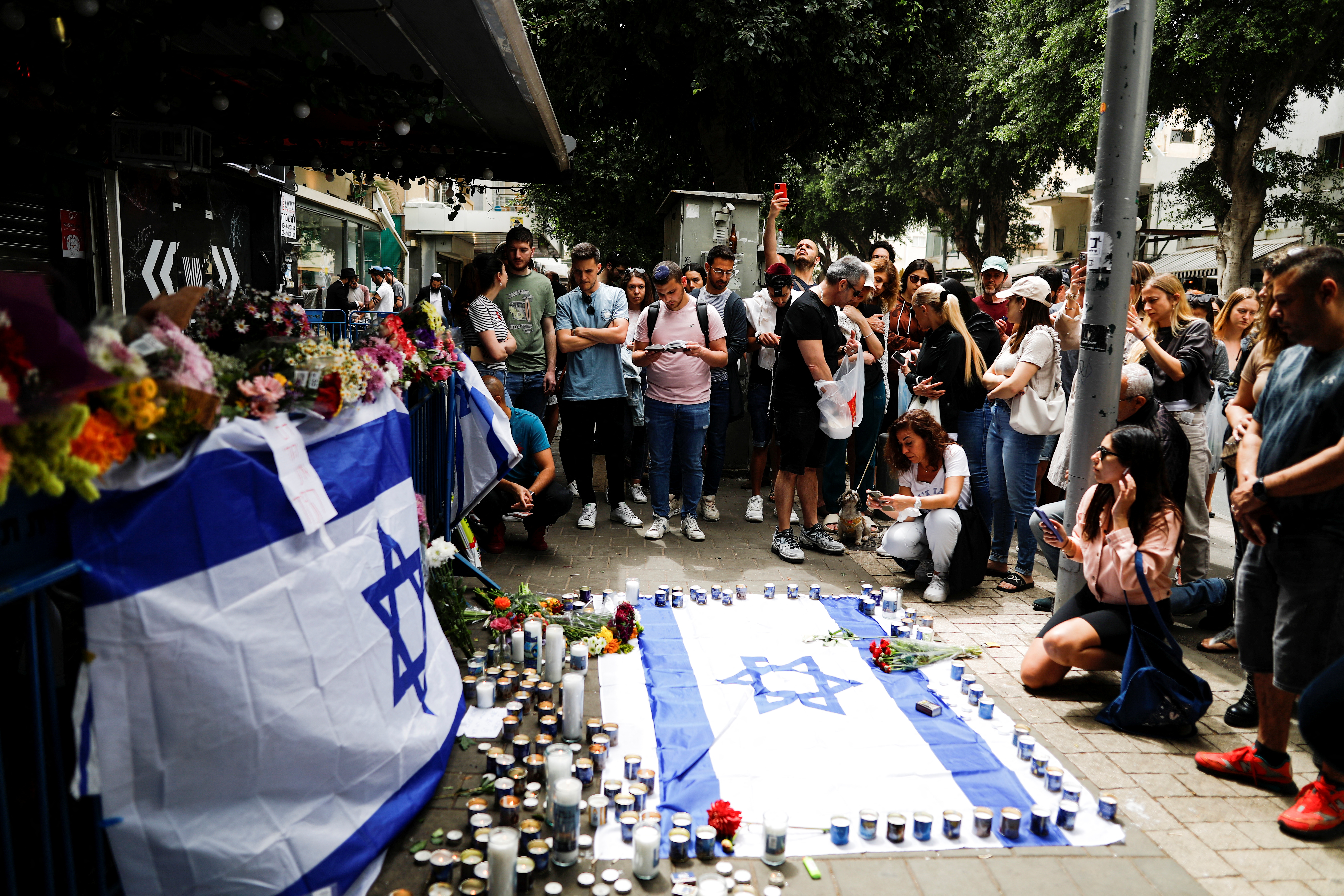 Israelis pay their respects outside a bar which was the site of a fatal shooting attack in Tel Aviv