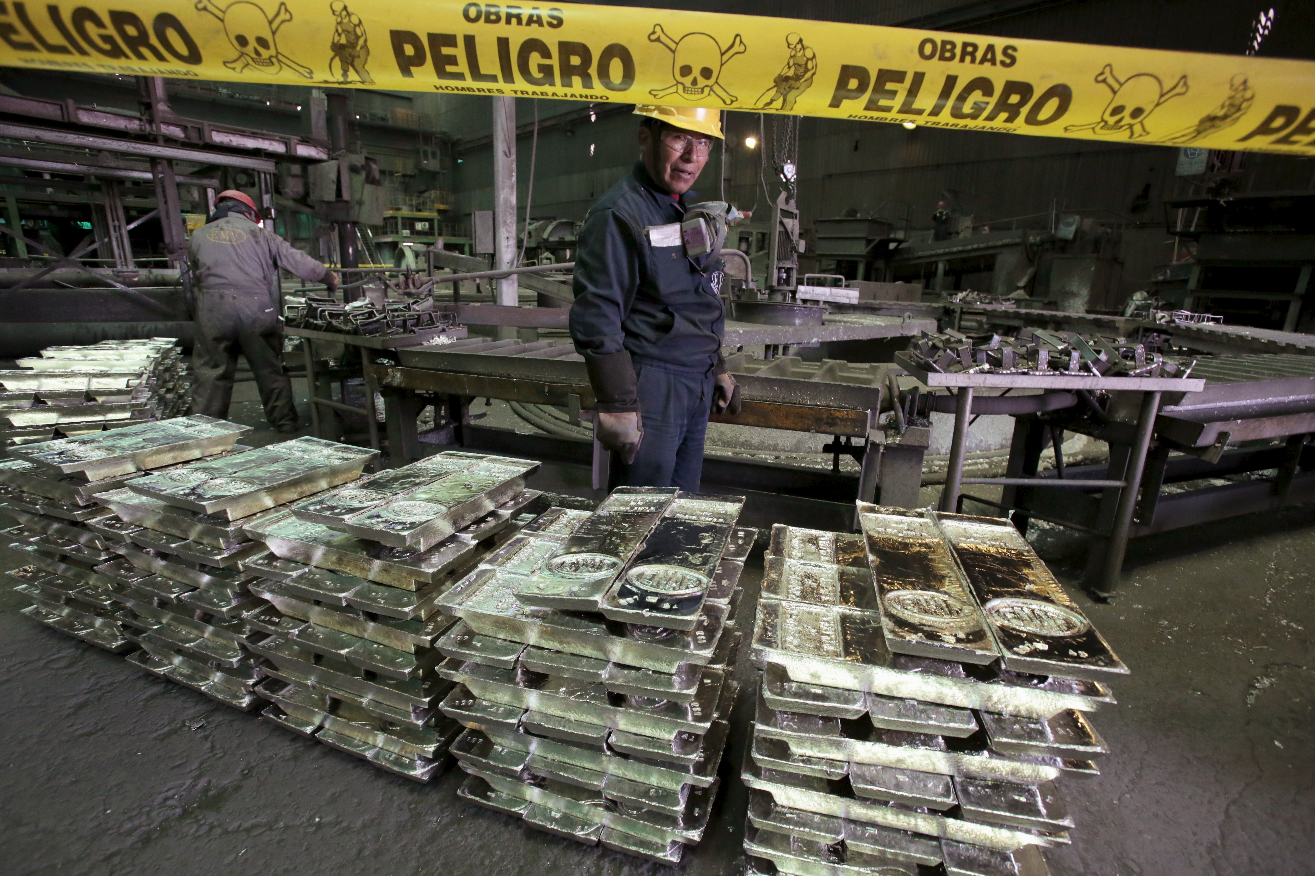 A worker stands next to tin ingots at the newly inaugurated Ausmelt tin smelter building in the town of Vinto