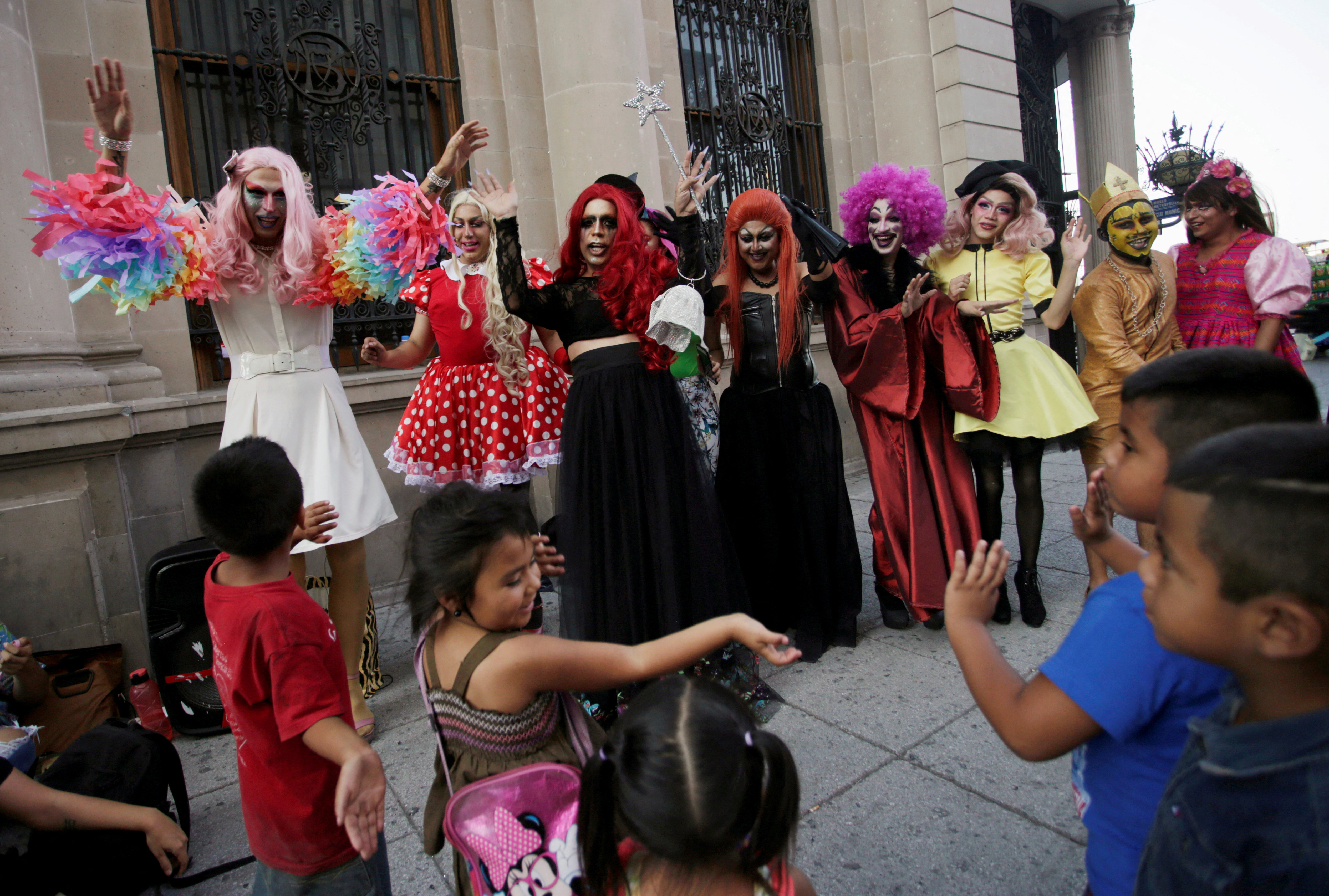 Participants dressed in drag dance along with children during the 