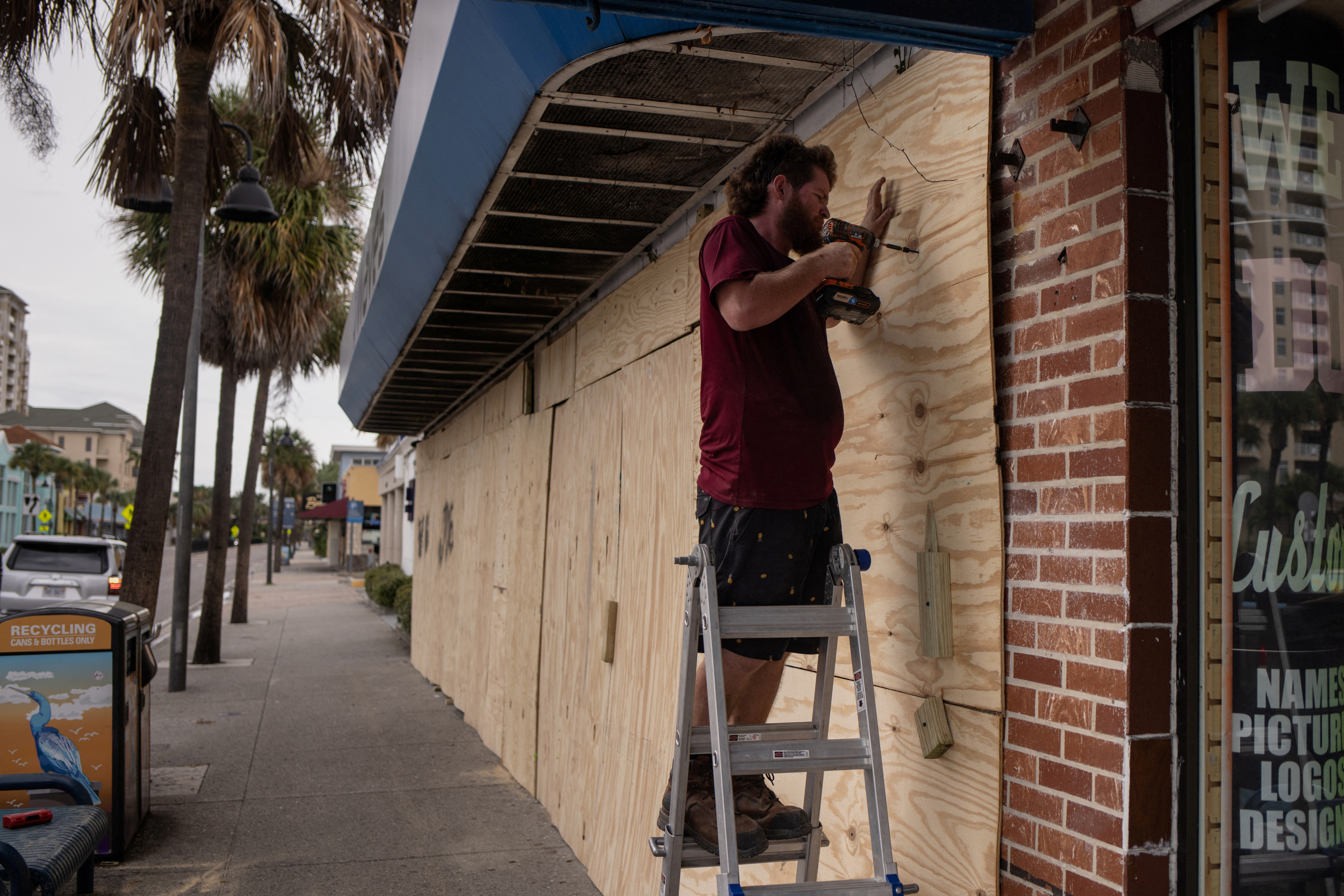 Man boards up storefront ahead of Hurricane Idalia in Clearwater Beach, Florida