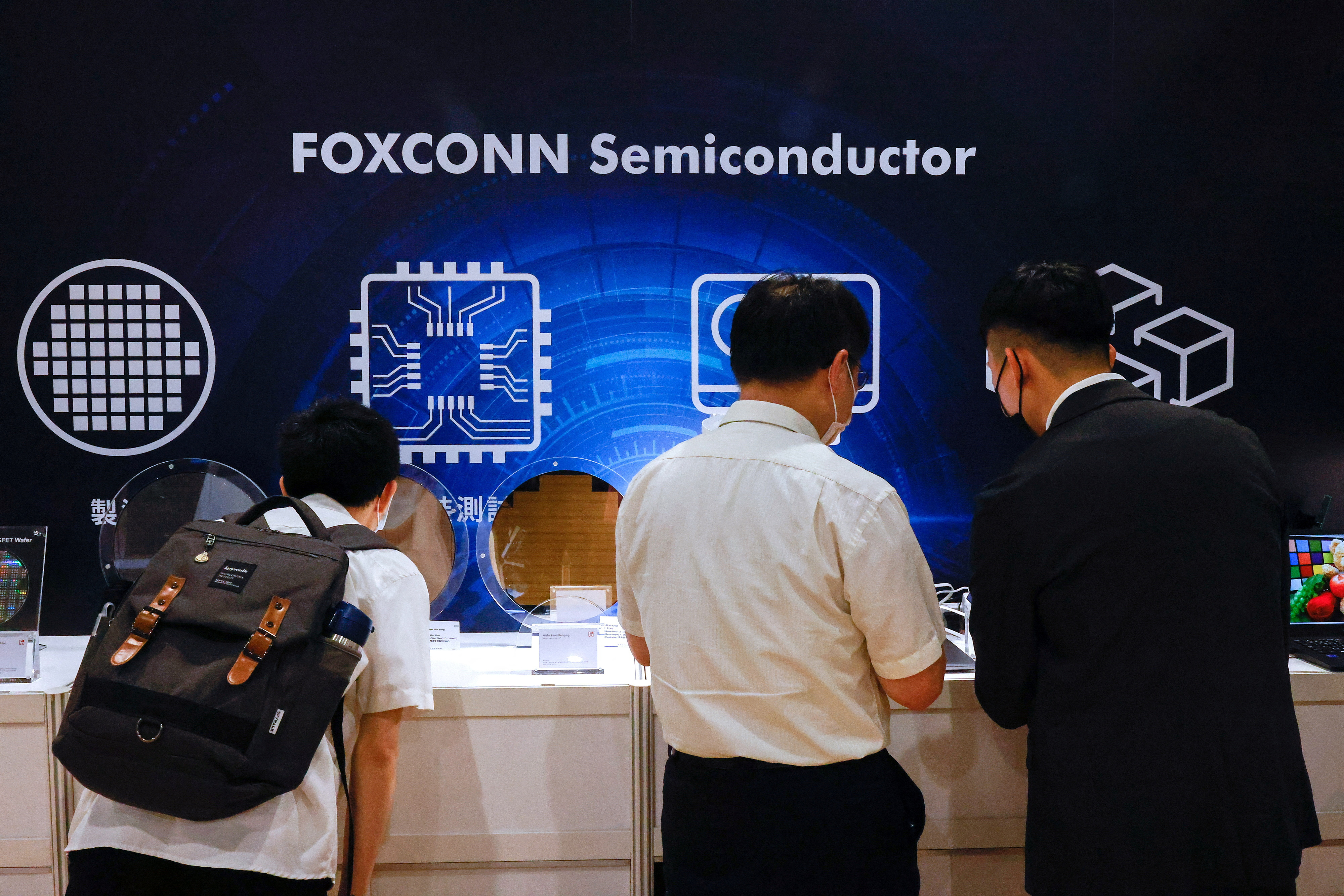 Foxconn shareholders look at wafers on display after the annual shareholder meeting in New Taipei City,