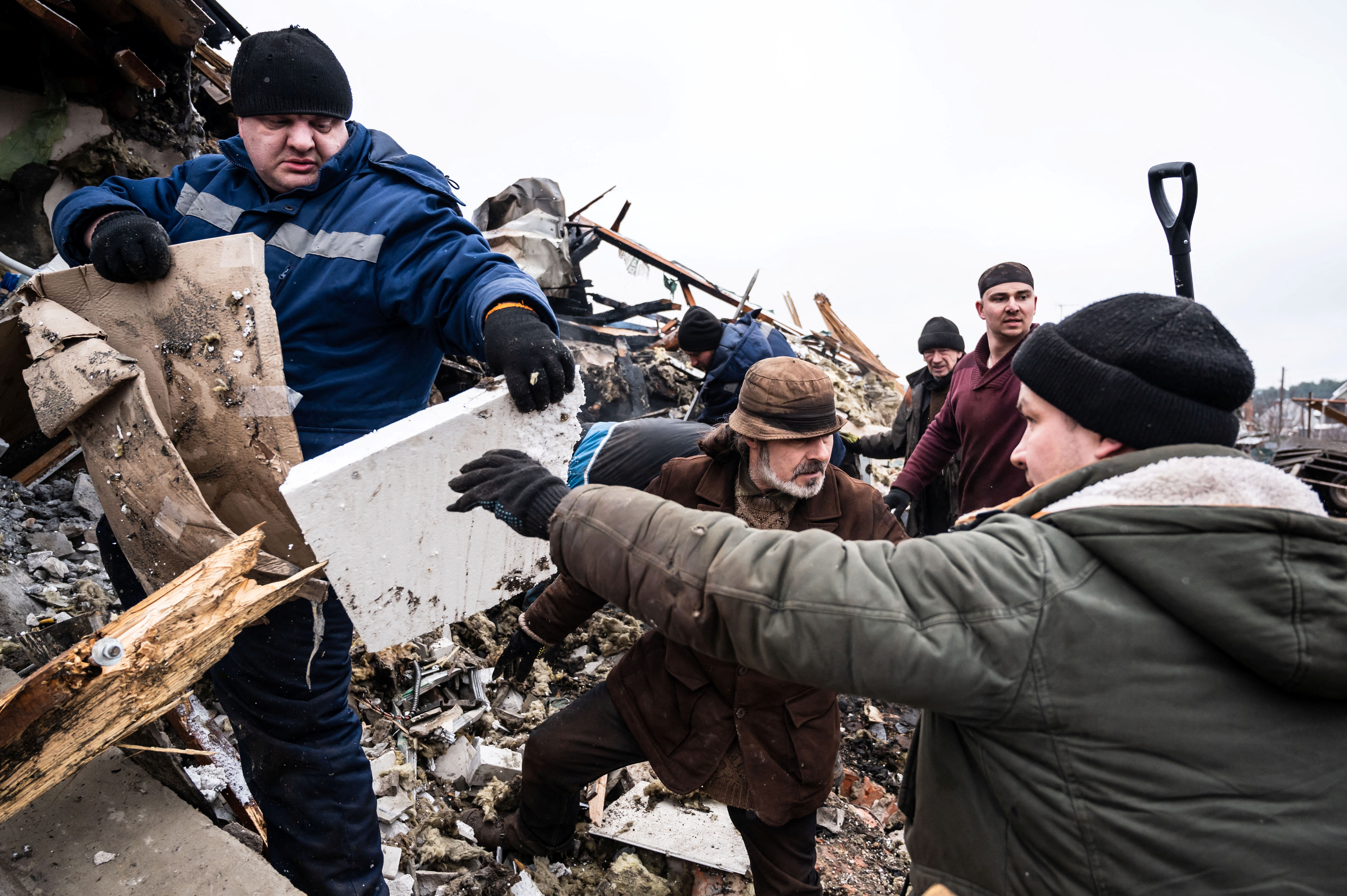 Local residents remove debris of a residential building destroyed by shelling, as Russia's invasion of Ukraine continues, in Zhytomyr