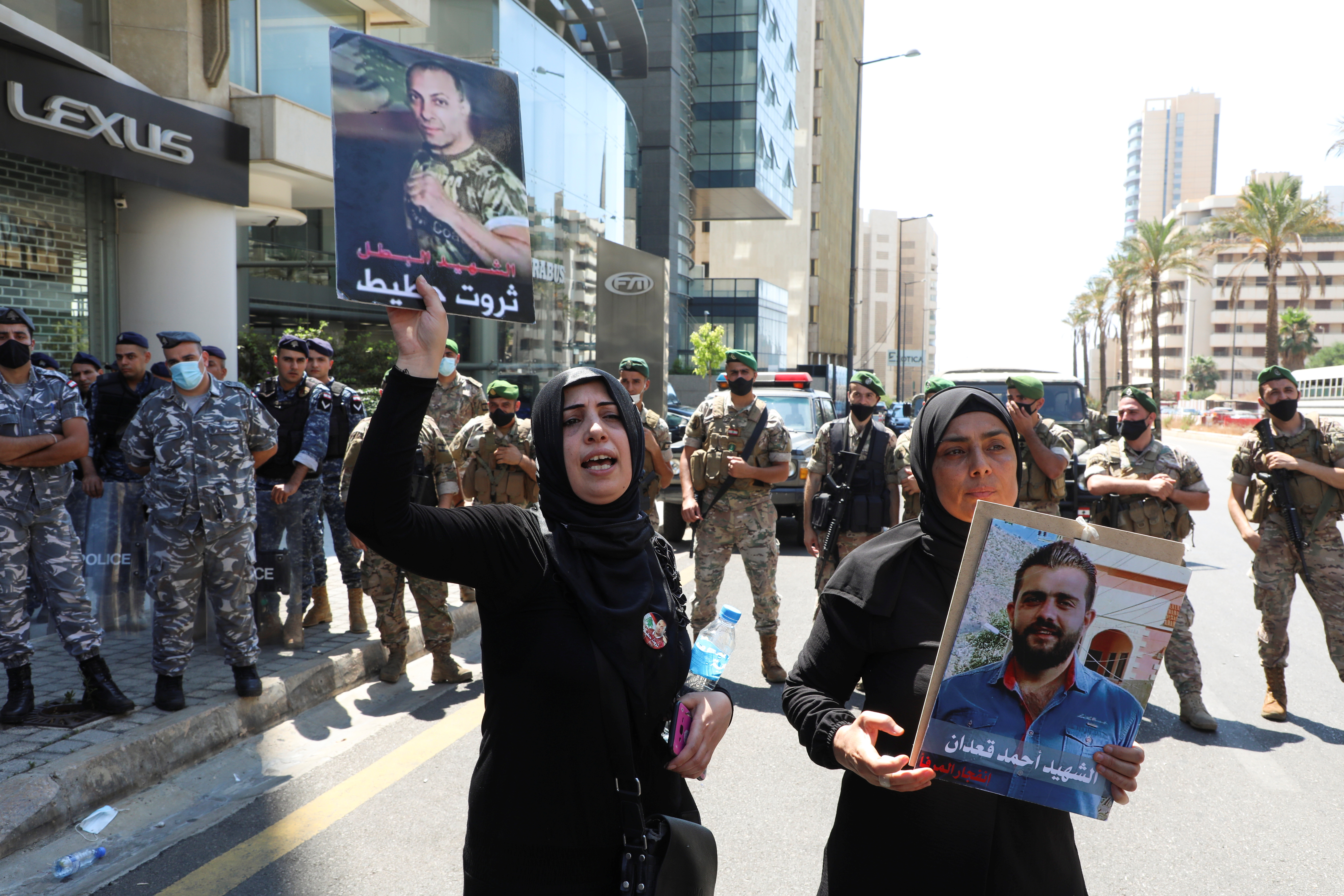Family members of some of the victims of the August 4 explosion at Beirut port, carry their pictures during a protest demanding justice, in Beirut