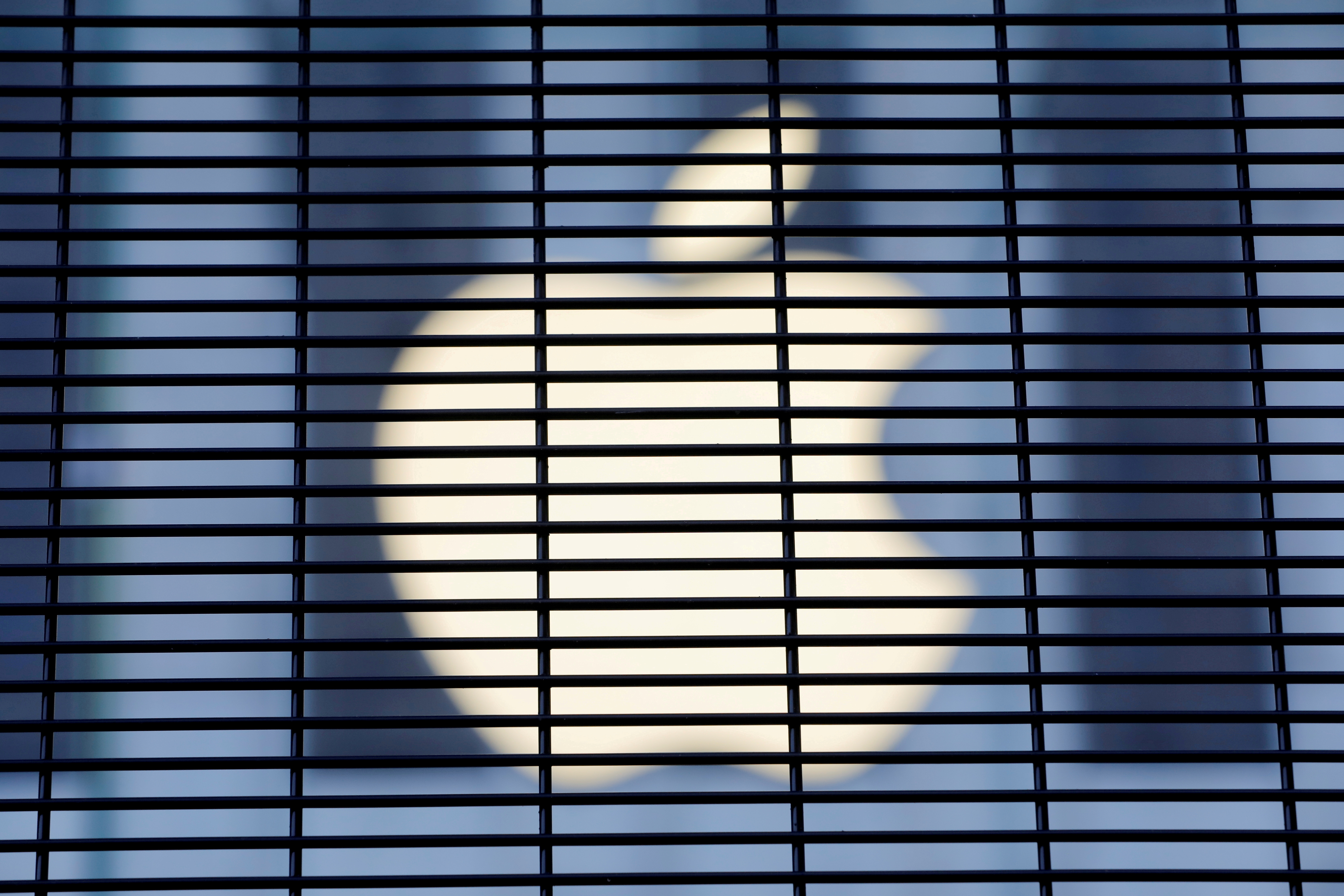 The Apple logo is seen through a security fence erected around the Apple Fifth Avenue store as votes continue to be counted following the 2020 U.S. presidential election, in Manhattan, New York City, U.S., November 5, 2020. REUTERS/Andrew Kelly/File Photo