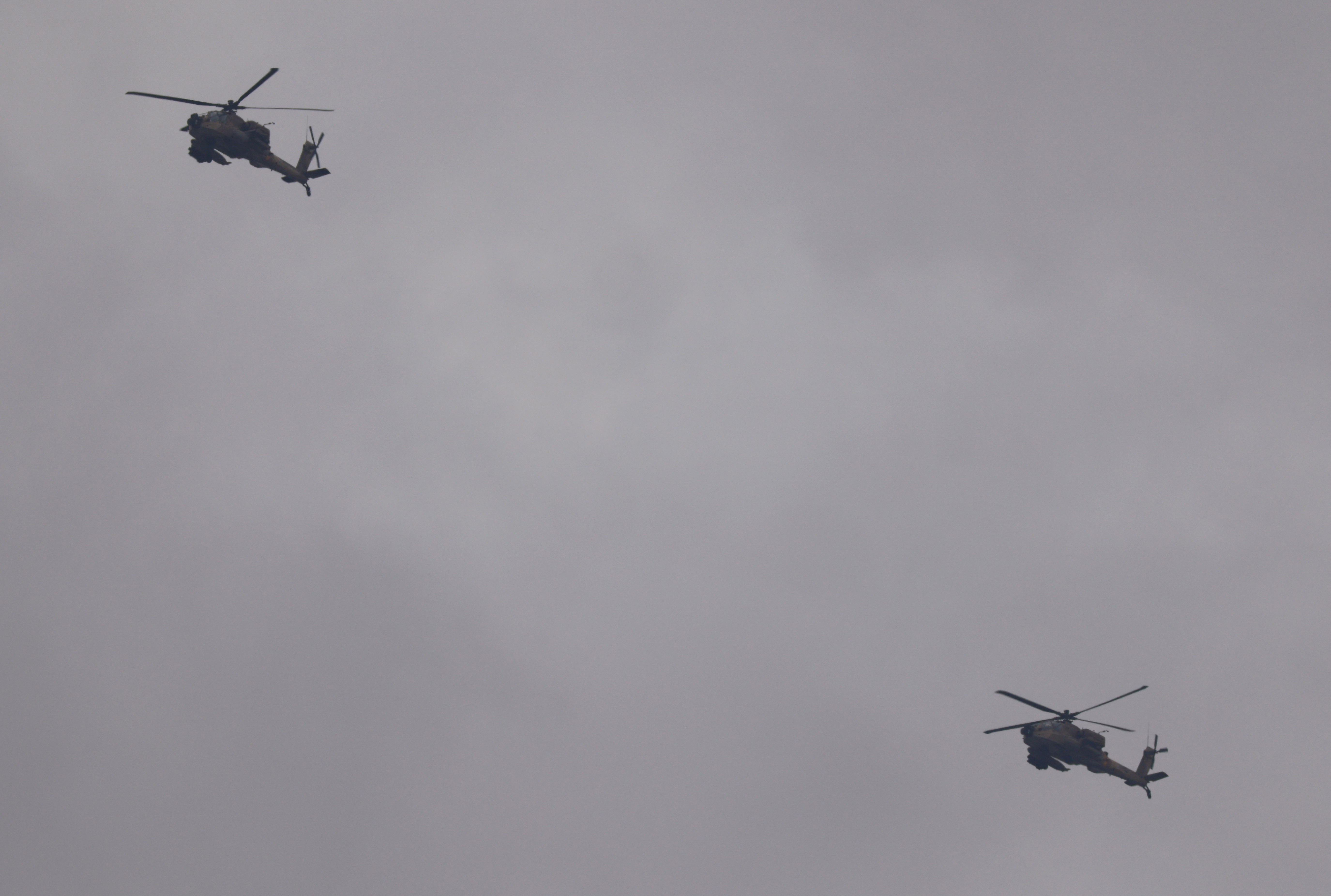 Israeli military Apache helicopters fly near the Israel-Gaza border as seen from southern Israel