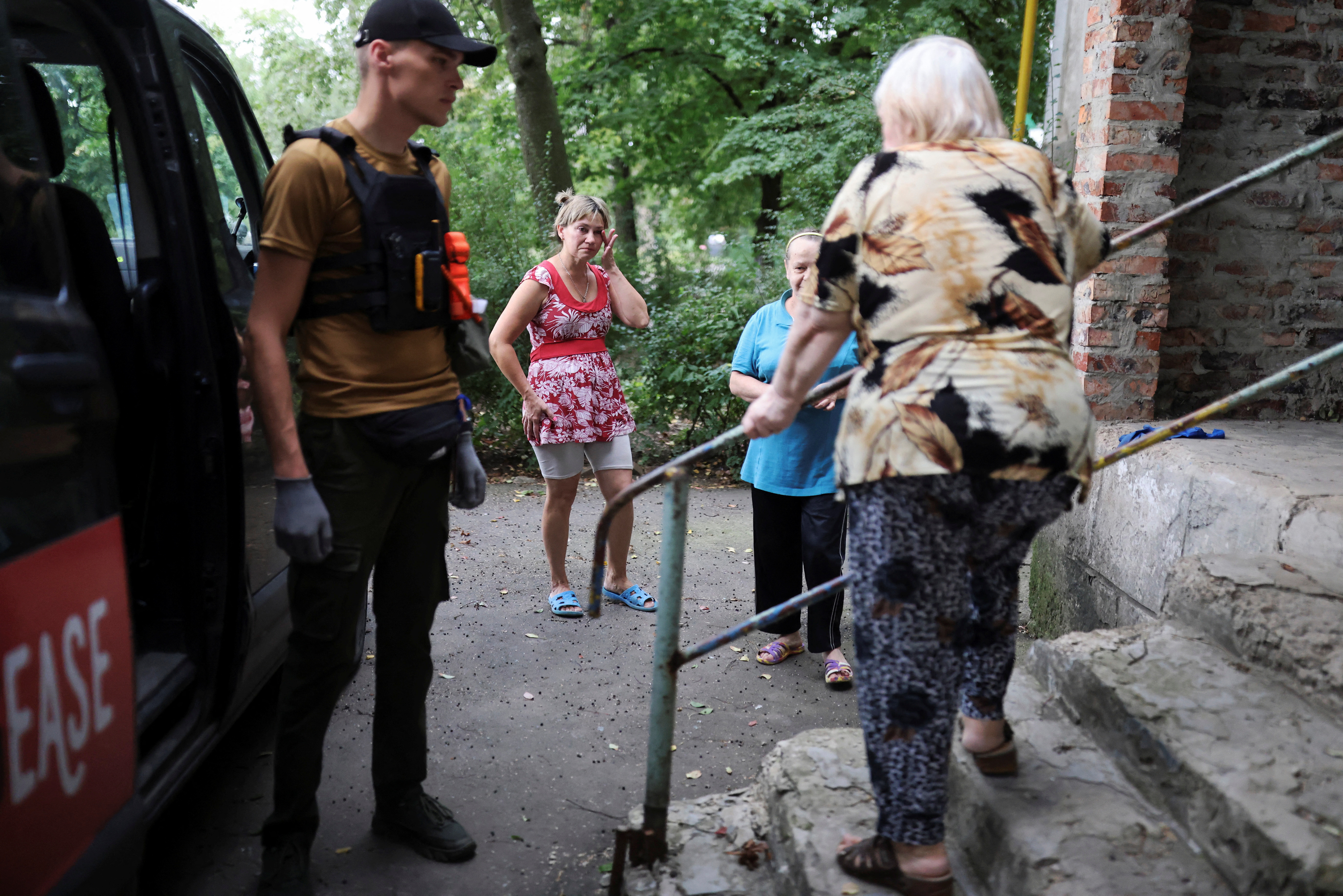 Neighbours of Zorina Zoya Alexandrovna, cry as she is evacuated from her house with the help of Eduard Skoryk, a member of the NGOs Vostok SOS and Refugease, in Bakhmut
