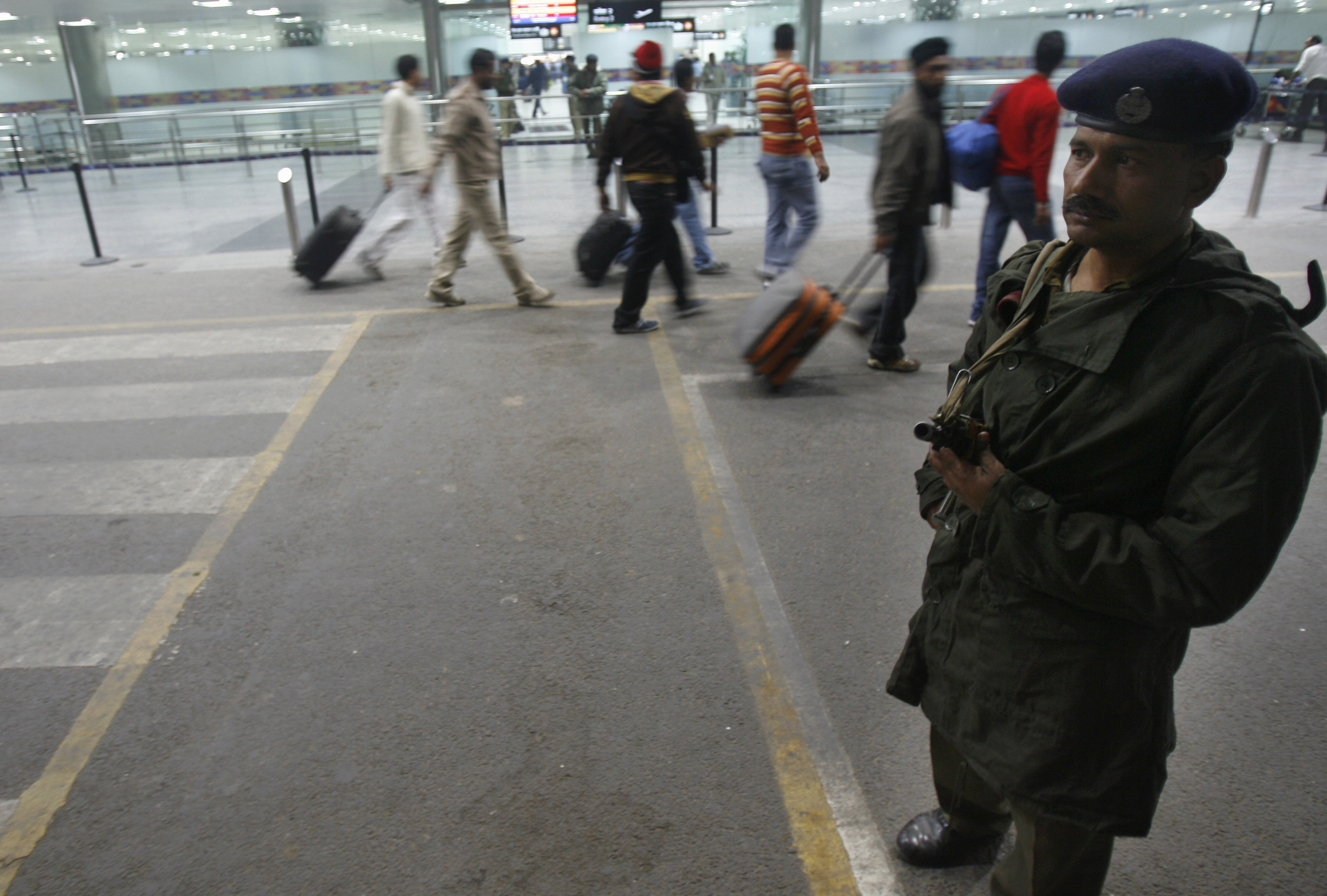A paramilitary soldier stands guard as passengers arrive at the international airport in New Delhi
