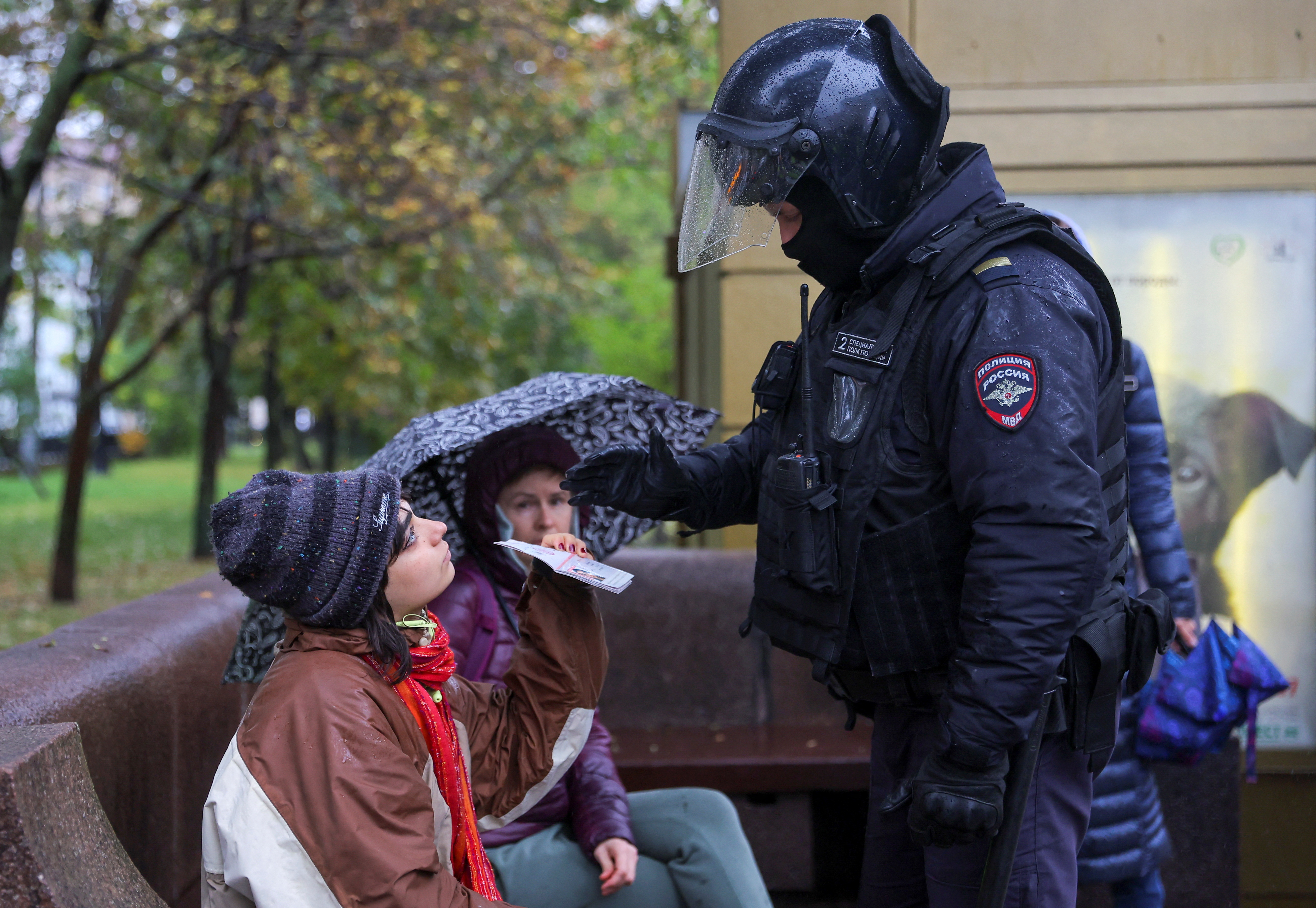 A Russian police officer checks a document during a rally in Moscow