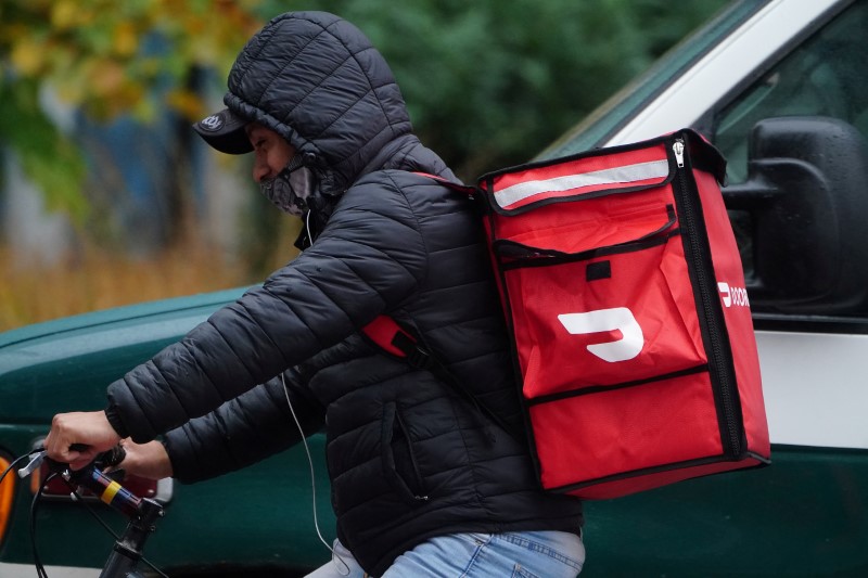 A delivery person for Doordash rides his bike in the rain during the coronavirus disease (COVID-19) pandemic in the Manhattan borough of New York City