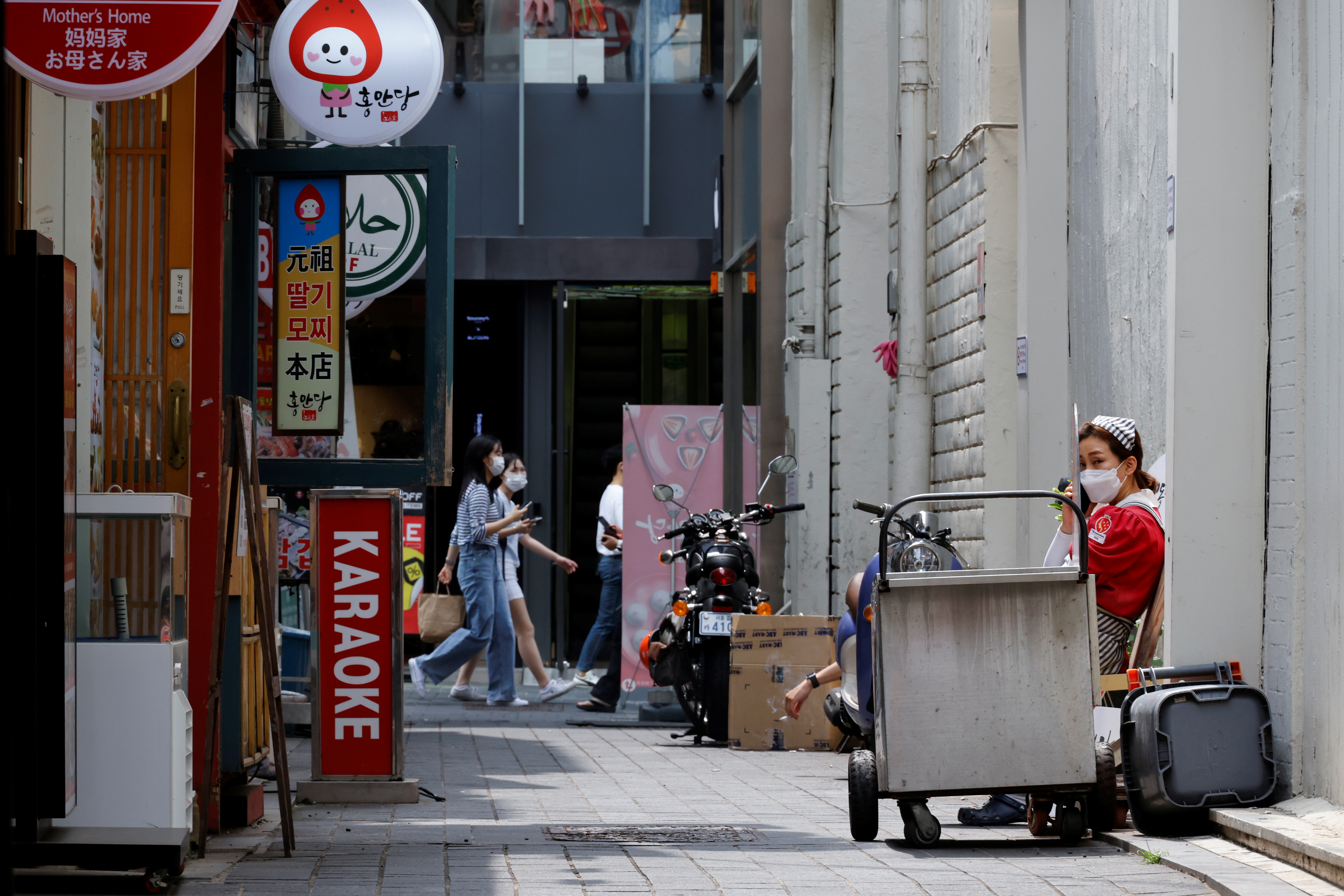 An employee takes a break outside a shop amid the coronavirus disease (COVID-19) pandemic in Seoul, South Korea, July 9, 2021.  REUTERS/ Heo Ran