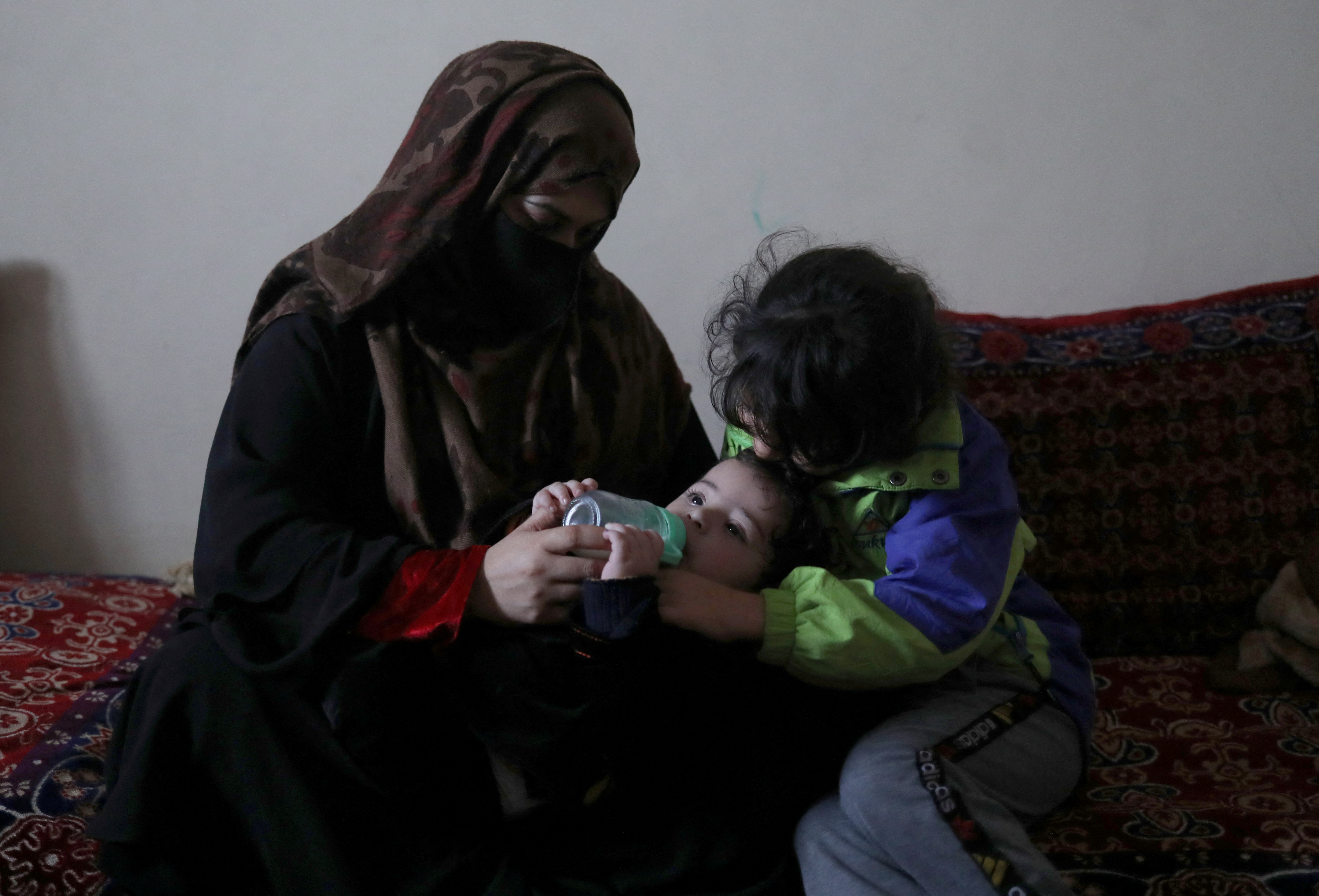 Farima Safi feeds baby Sohail Ahmadi at her house in Kabul