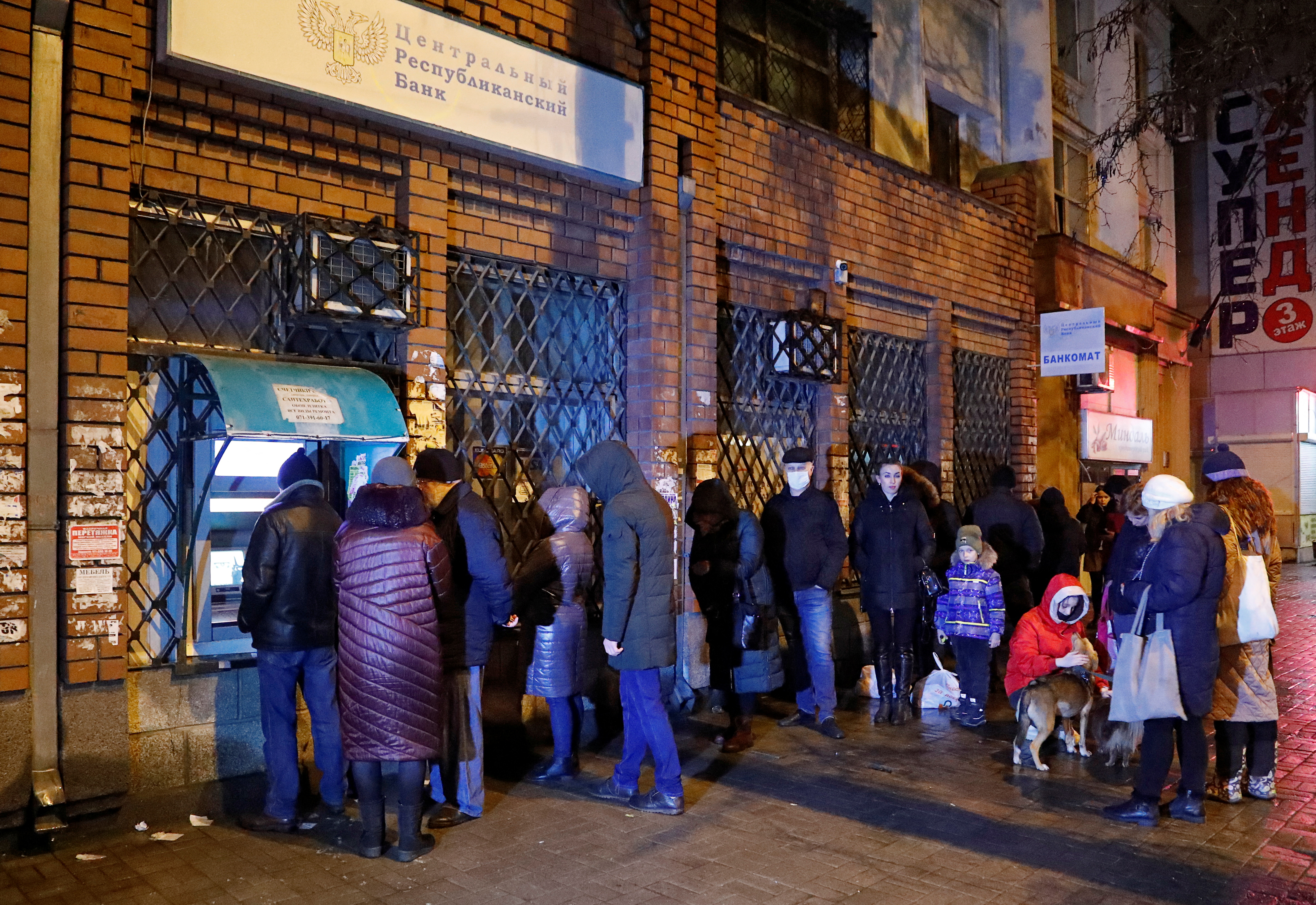 People stand in line to use an ATM cash machine in Donetsk