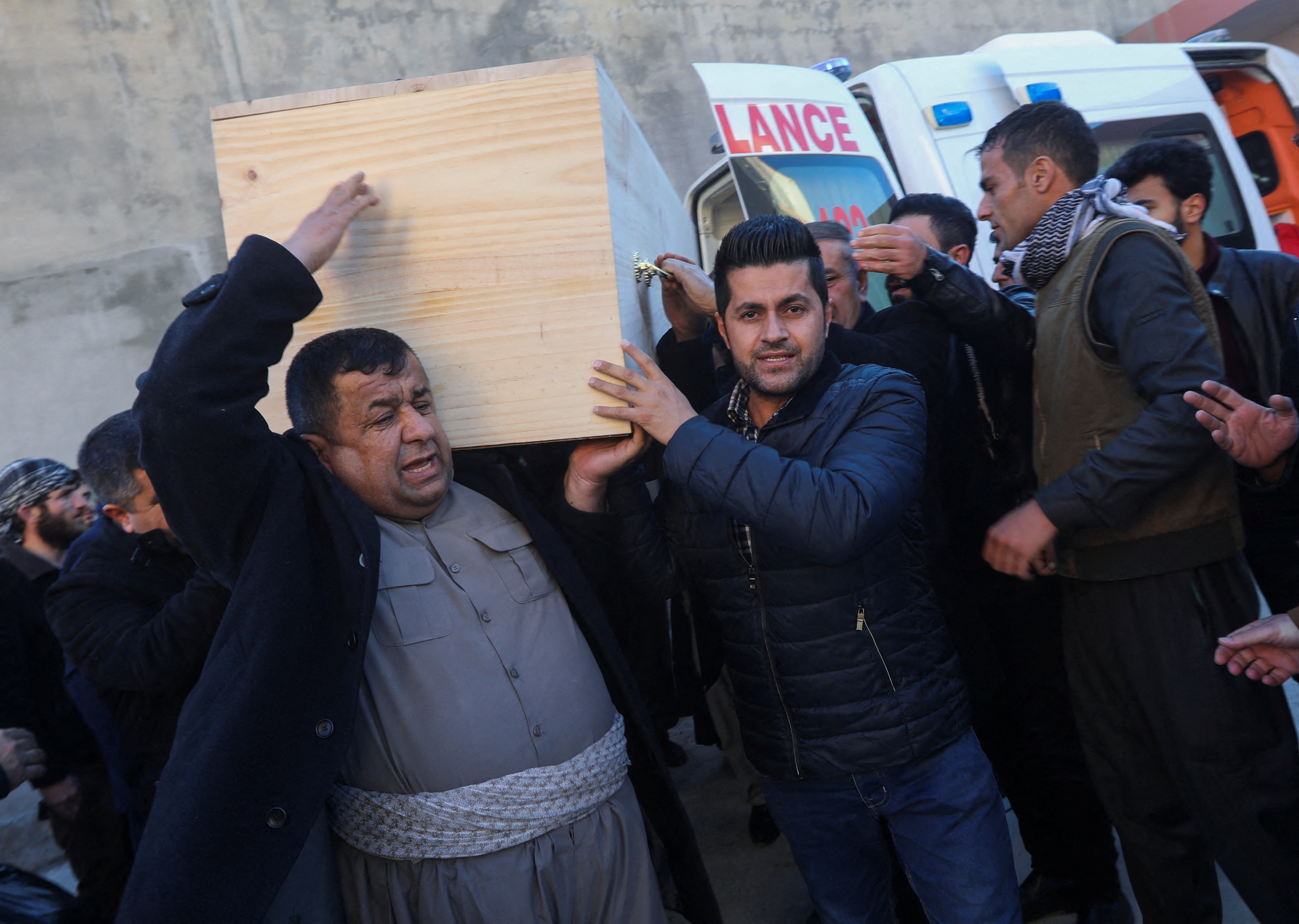 People carry one of the coffins of Iraqi Kurdish migrants who drowned while trying to cross the channel between France and Britain, in the town of Rania, Sulaimaniyah province, Iraq, December 26, 2021. REUTERS/Ako Rasheed