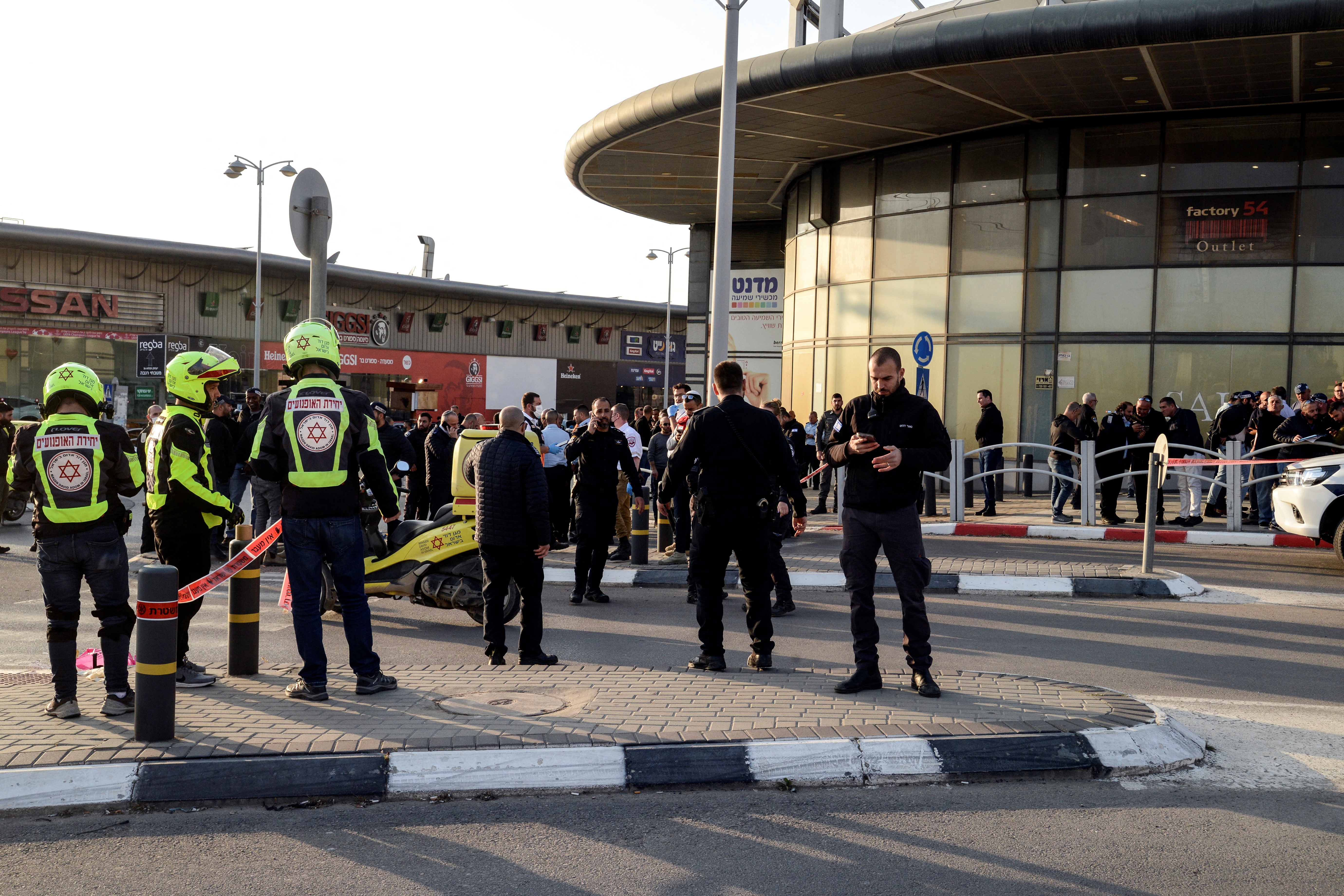 Israeli security and rescue forces secure the scene of an attack in which people were killed near a shopping centre in Beersheba