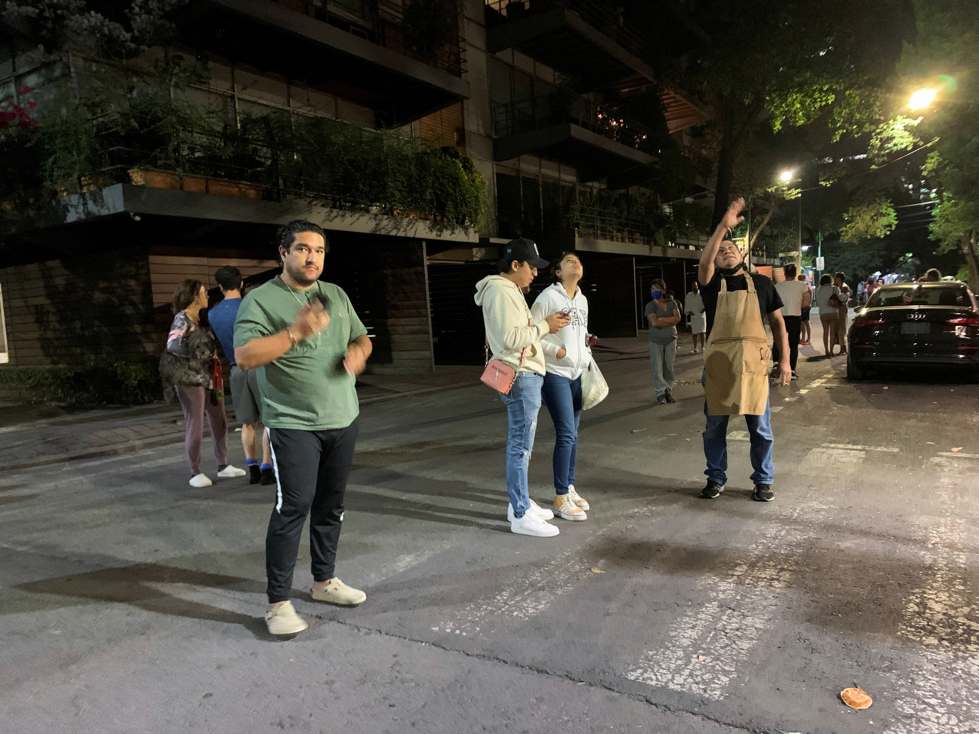 People wait outside their homes after a tremor was felt in Mexico City