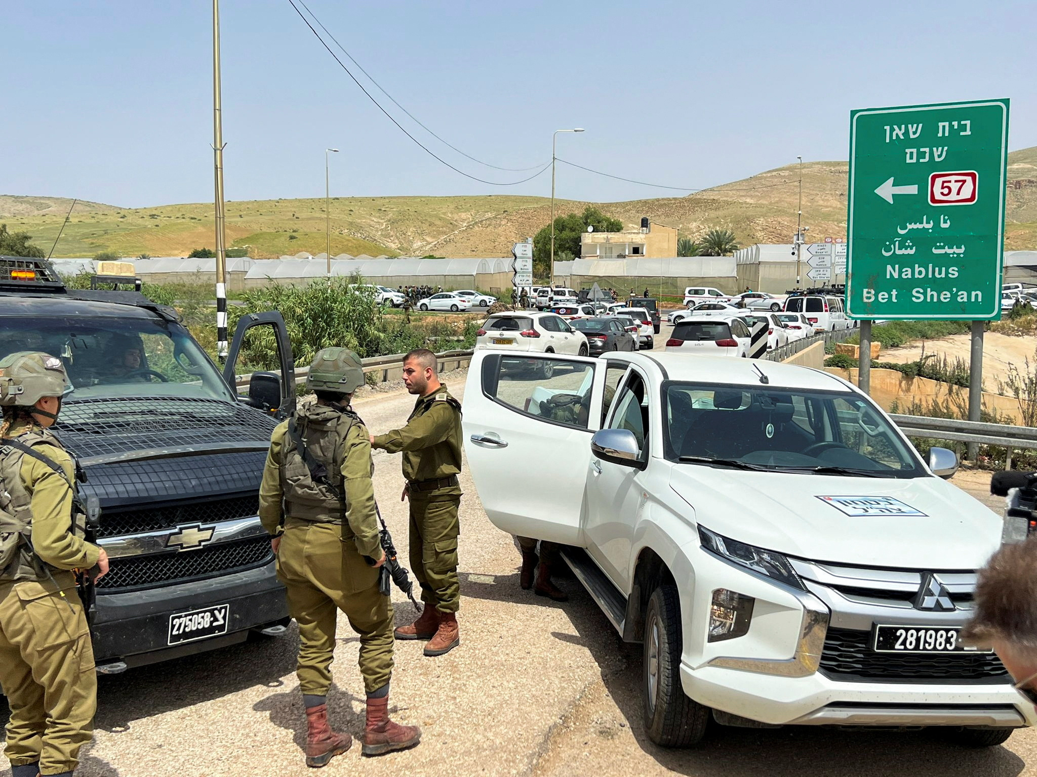 Israeli troops stand guard at a shooting attack scene in the Jordan Valley