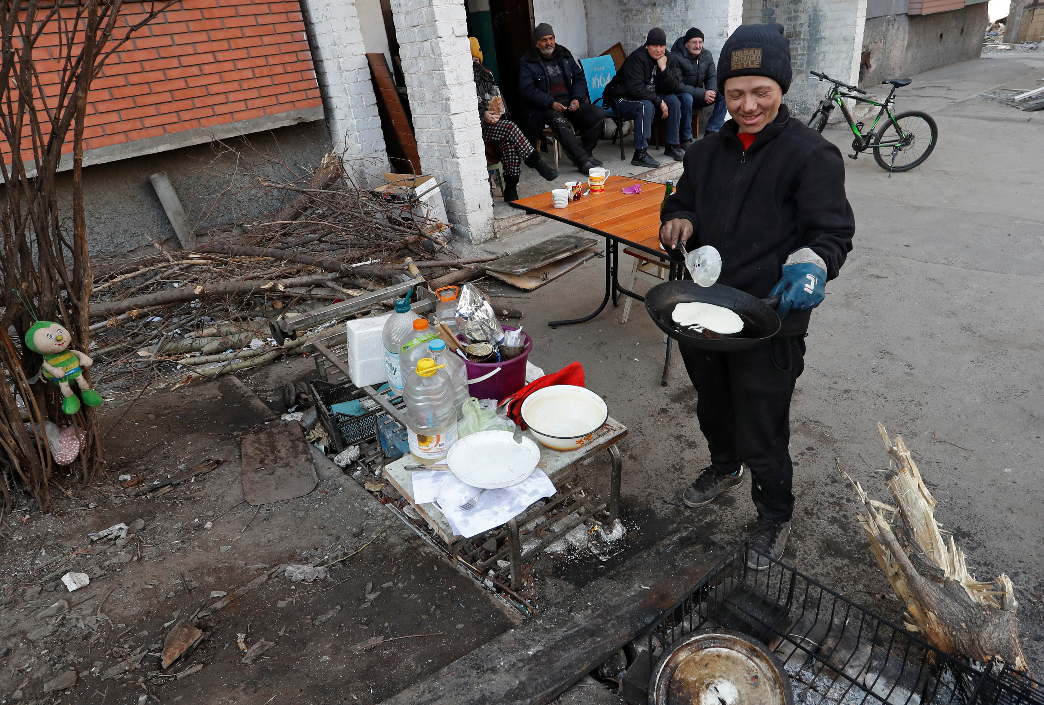 Local resident Yekaterina Lanina cooks pancakes outside an apartment building in Mariupol