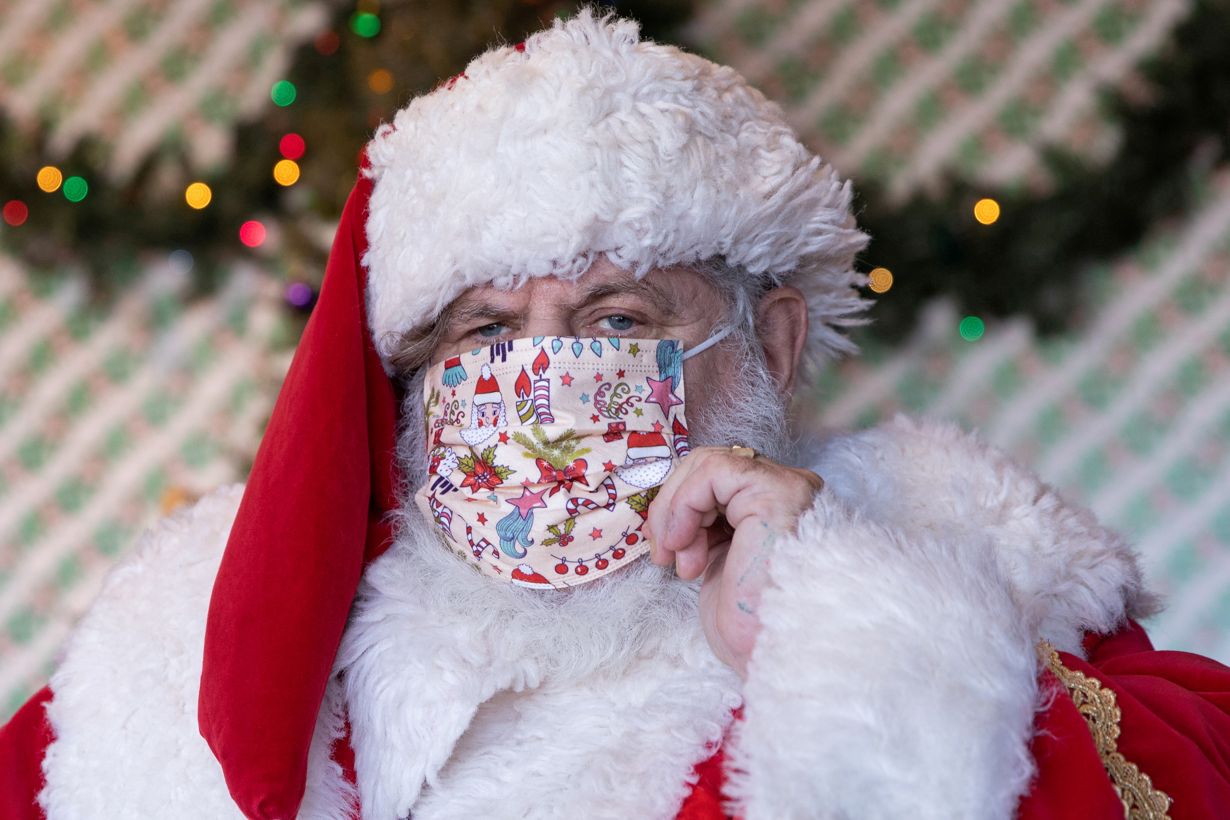 Dana Friedman adjusts his mask before greeting a child at the Bay Terrace Shopping Center in Queens in New York City, U.S., December 6, 2020. REUTERS/Caitlin Ochs/File Photo