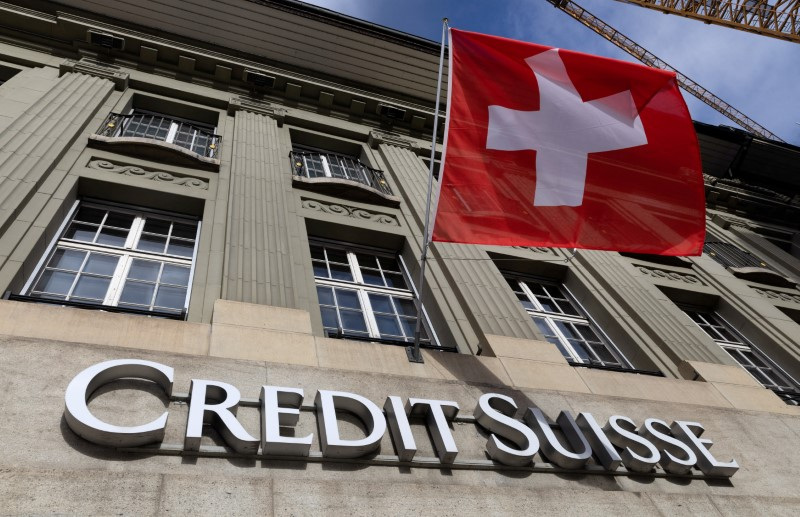 A Swiss flag is pictured above a logo of Credit Suisse in Bern