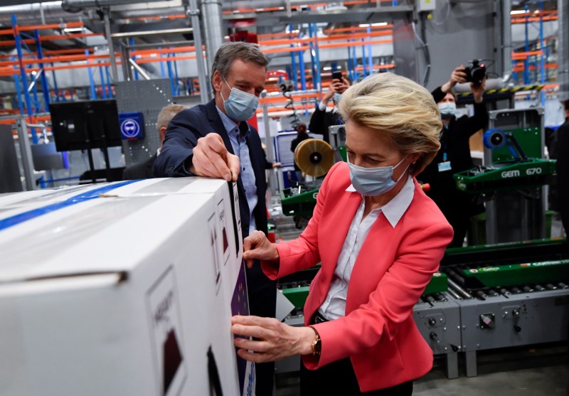 European Commission President Ursula von der Leyen sticks an EU flag label during a visit at the factory of U.S. pharmaceutical company Pfizer in Puurs, Belgium April 23, 2021. John Thys /Pool via REUTERS/File Photo