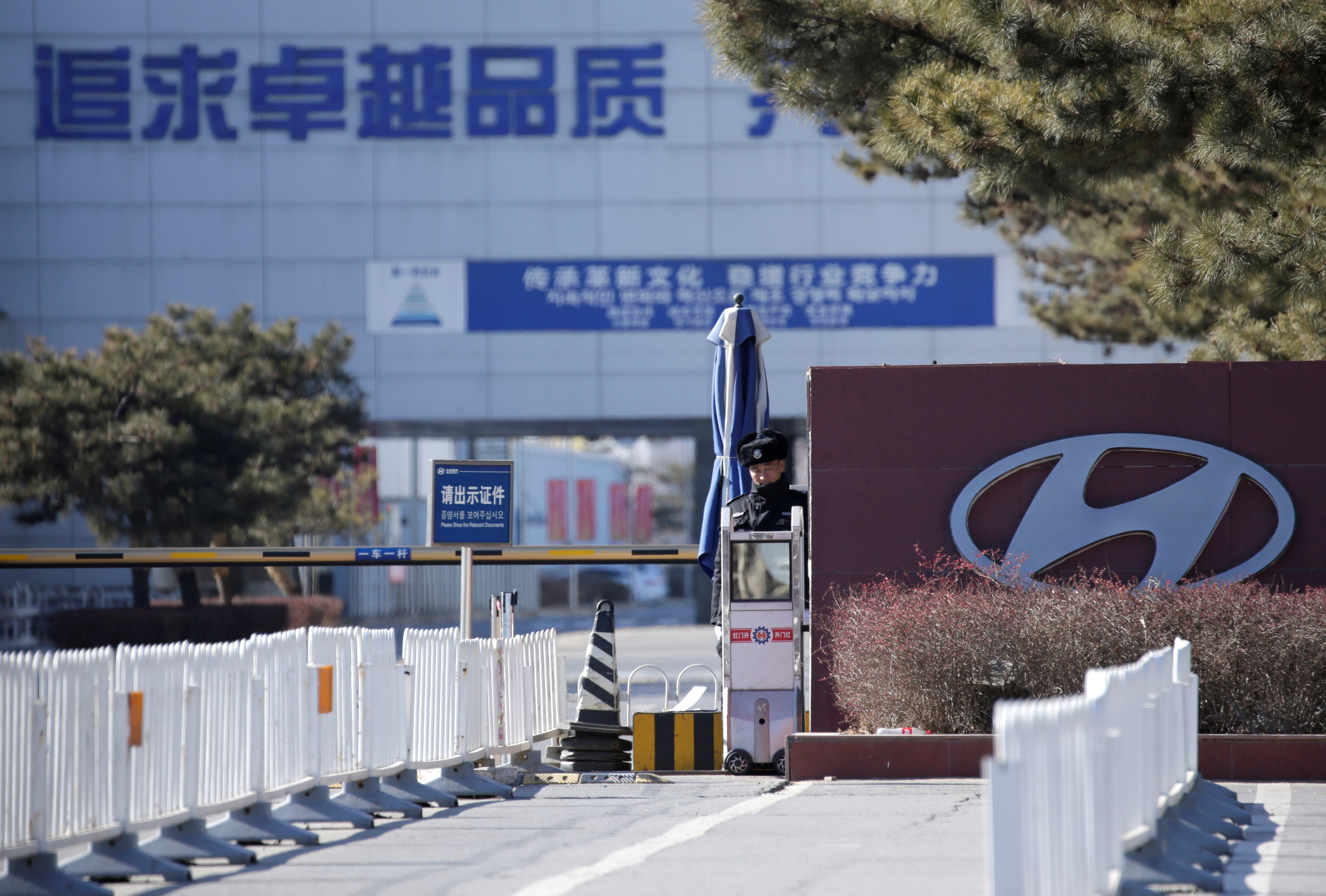 A security guard is seen at the main entrance of a plant of Hyundai Motor Co on the outskirts of Beijing