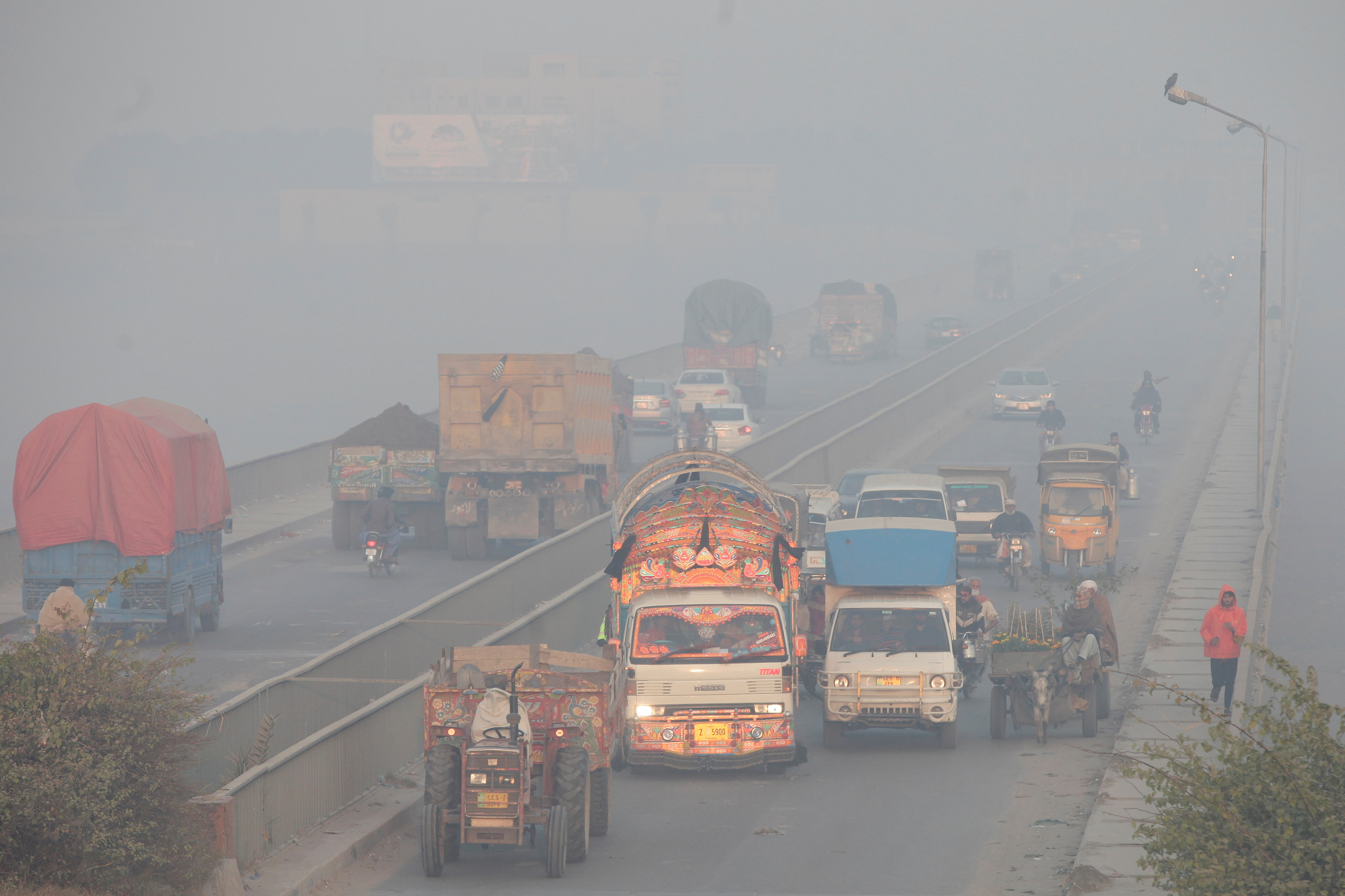 Veículos se movem em meio a espessa poluição em Lahore